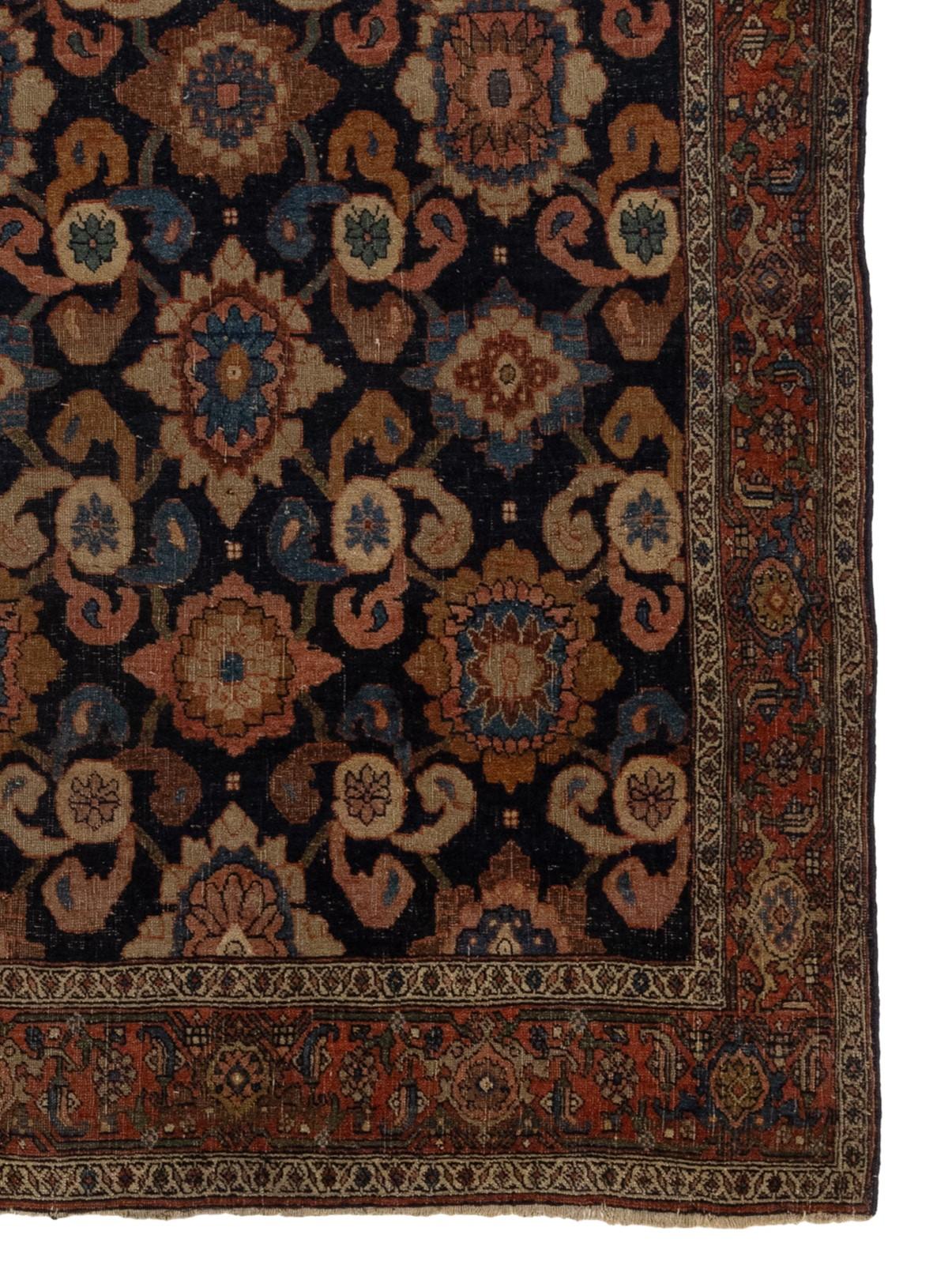 Ce magnifique tapis ancien date de la fin du XIXe siècle, plus précisément des années 1880. Il présente un motif floral époustouflant qui orne un riche velours de laine bleu marine, reposant sur une base de laine. L'attrait indéfectible du tapis et