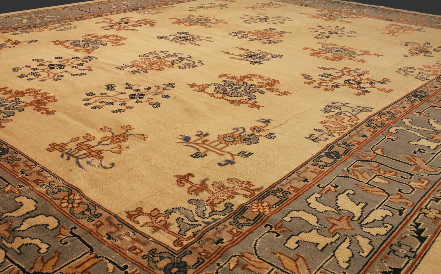 Dies ist ein antiker türkischer Izmir-Teppich, der im ersten Viertel des 20. Jahrhunderts um 1920 gewebt wurde und 440 x 370 cm groß ist. Er hat ein Allover-Muster mit verschiedenen großflächigen, geometrisch gezeichneten Blumenmotiven, die sich