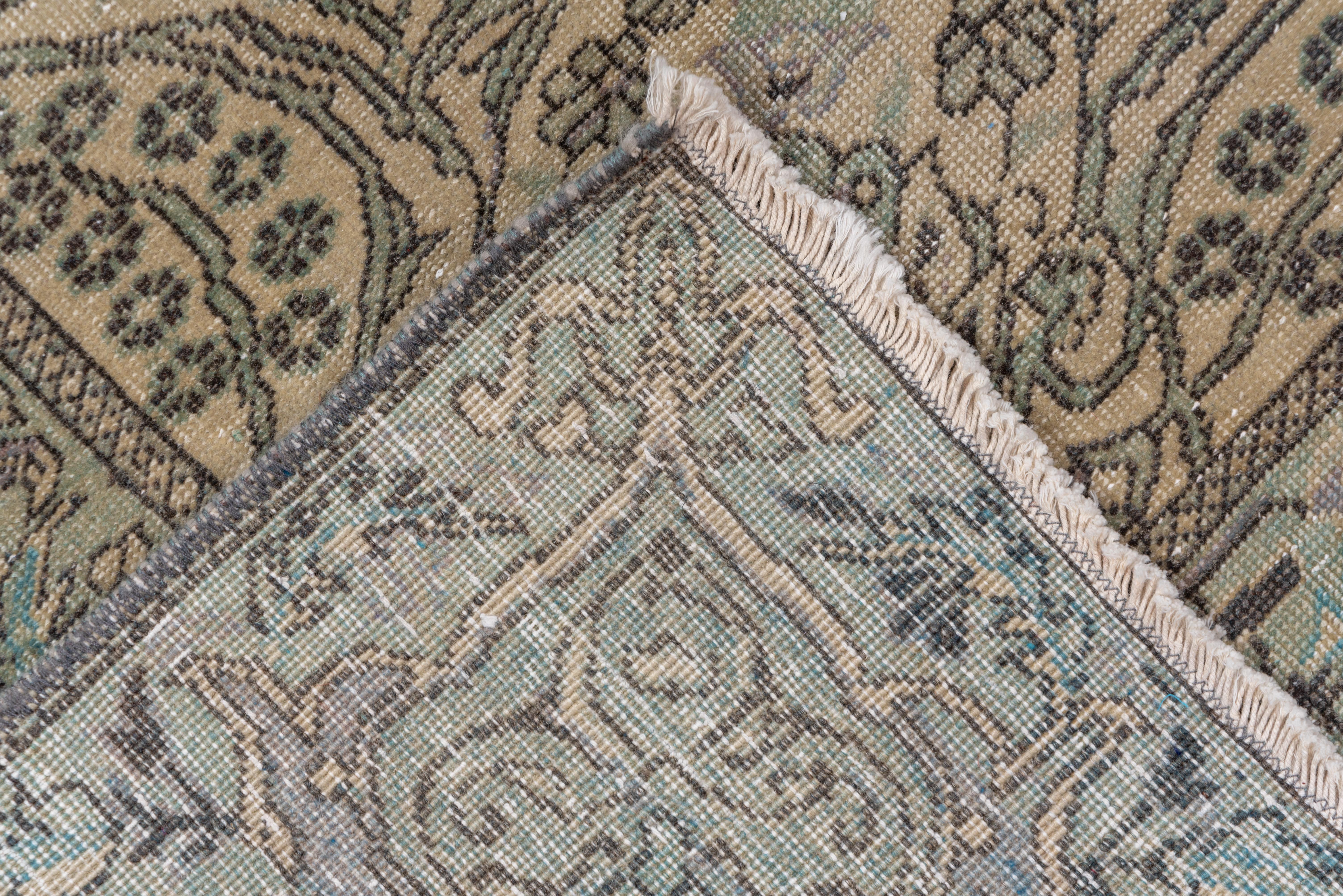 Das beigefarbene Feld ist stark vom zeitgenössischen persischen Design beeinflußt und zeigt blühende Zweige um ein spitzes Rautenmedaillon und eine von Halbkartuschen unterbrochene Bordüre. Dunkelbraune Umrisse und Details.