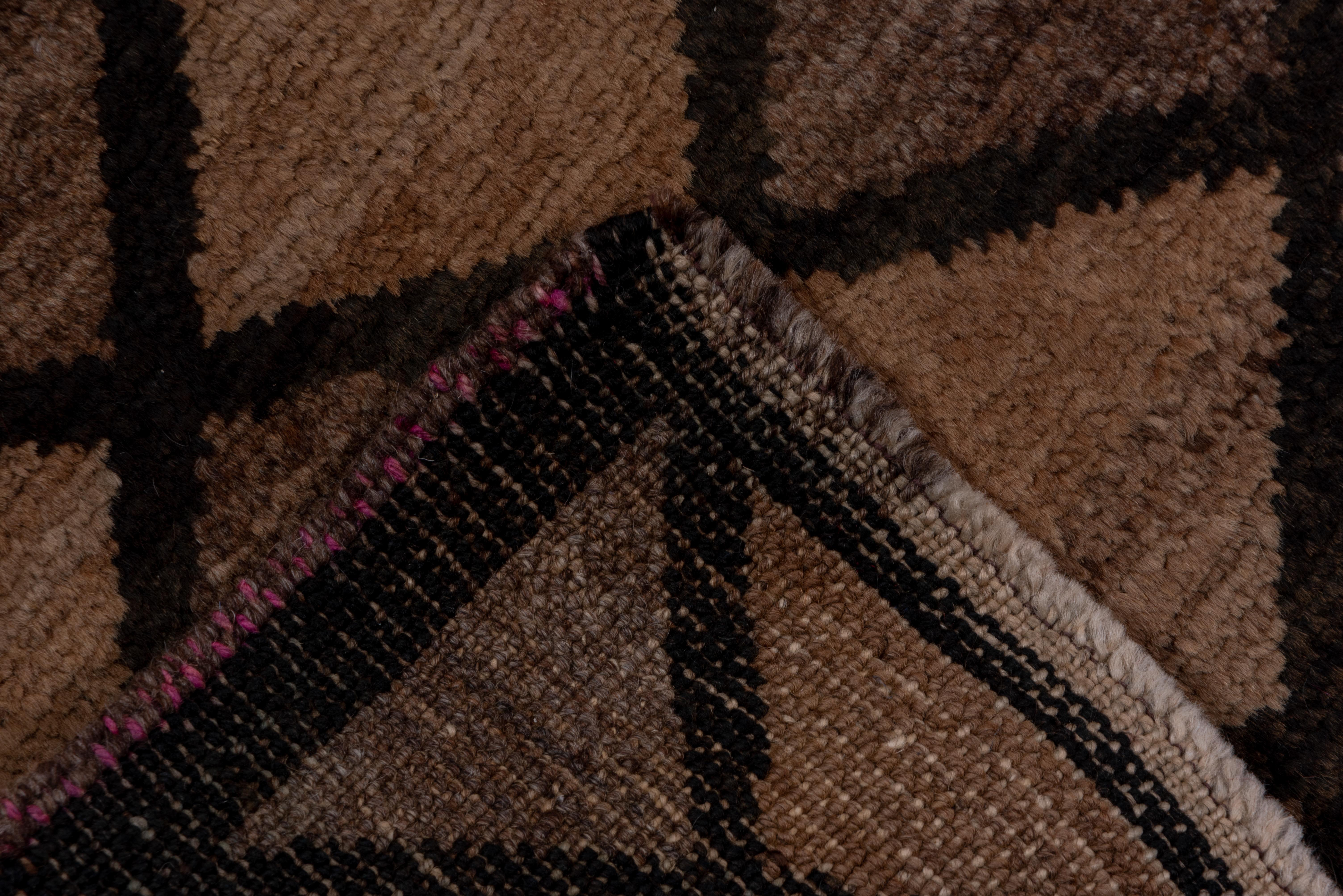 The dark brown lozenge lattice divides the field into a uniform harlequin tessellation of abrashed brown and beige pieces. Hairline dark brown border. Abrash is virtually continuous along the carpet length. Vintage era.