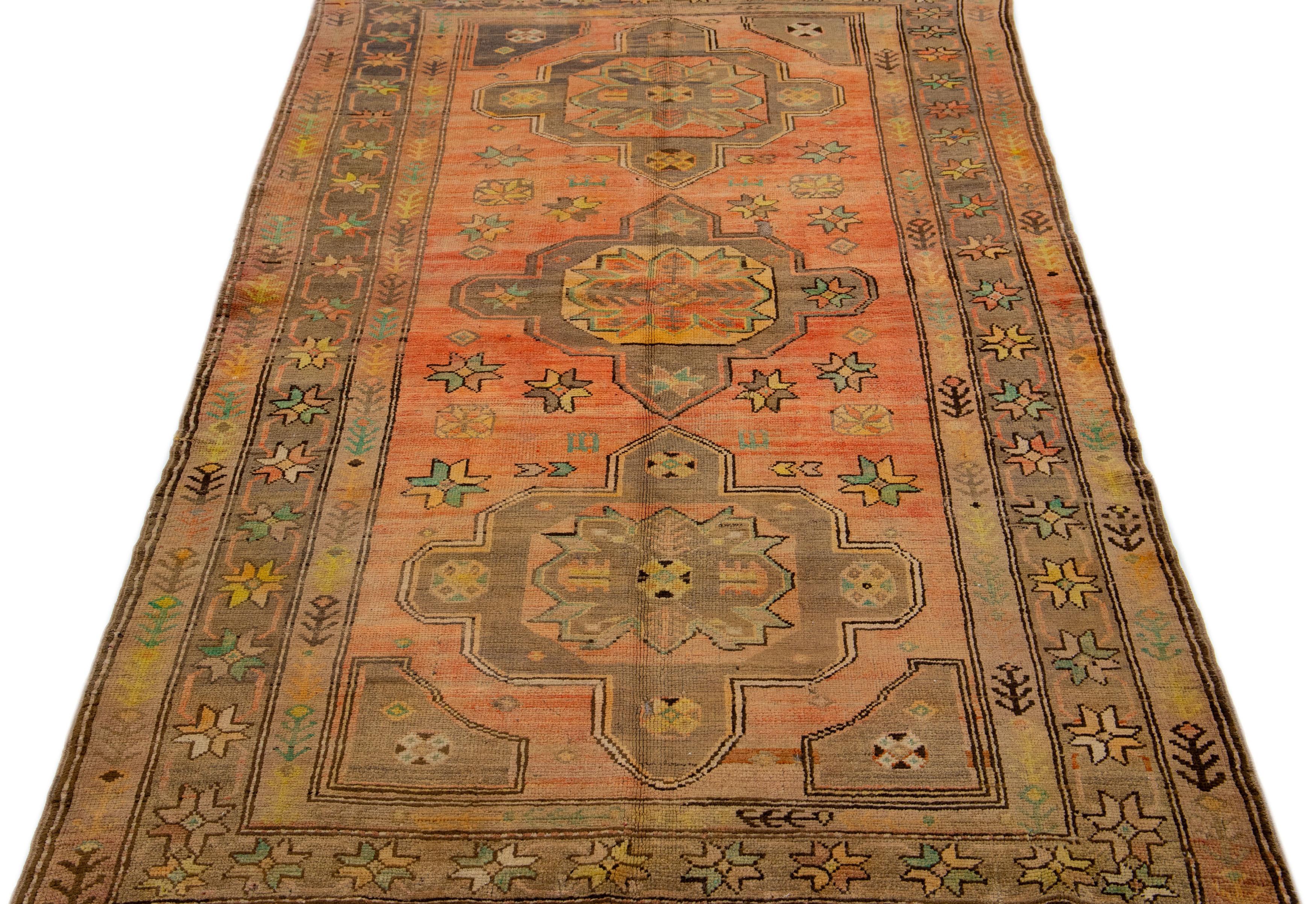 Beautiful Antique Turkish Khotan Hand-knotted wool rug with a terracotta field. This Khotan rug has yellow, blue, and gray accents in a gorgeous all-over tribal design.

This runner measures 4'5