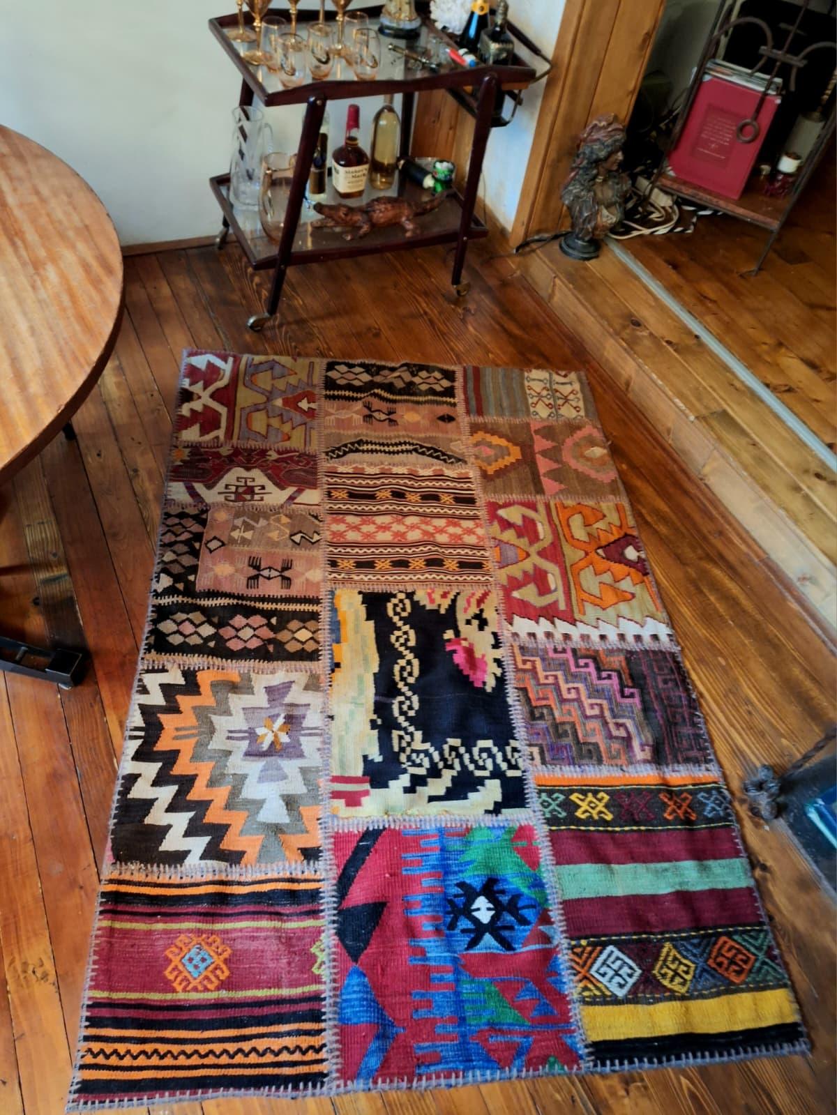 Un antico kilim turco patchwork è un tessuto unico, realizzato a mano unendo frammenti di vecchi kilim anatolici, ognuno dei quali porta con sé la propria storia, il proprio simbolismo e l'artigianato regionale. Tradizionalmente tessuti in pura lana