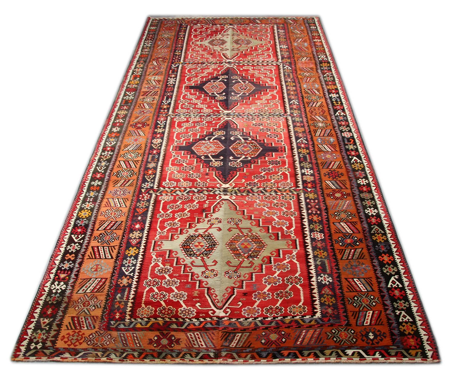 This floor rug is a Turkish carpet rug has woven by very skilled weavers in Turkey, who used the highest quality wool and cotton. The flat-weave rug has light red, rust, grey-green, white, gold, yellow and dark brown colors. The rust-red background