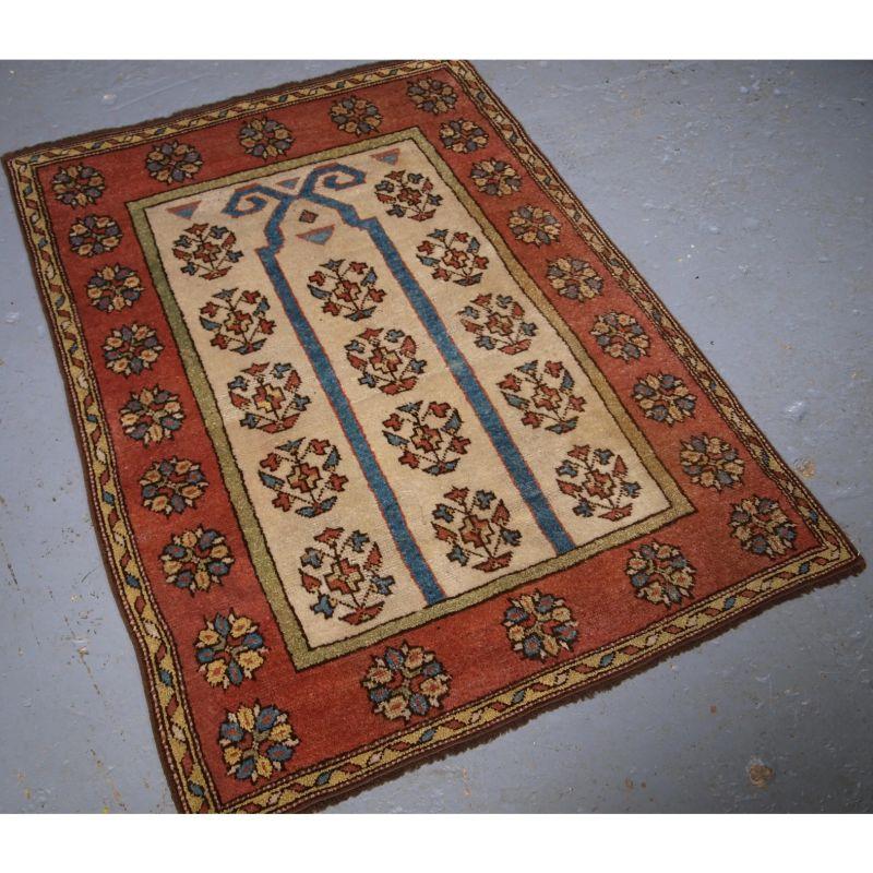 Antique Turkish Manastir prayer rug of outstanding simple design with a rams horn mihrab.

The rug is beautifully drawn with superb pastel colours through out. The ivory field has a repeat design of flowering shrubs, and rising through them is a
