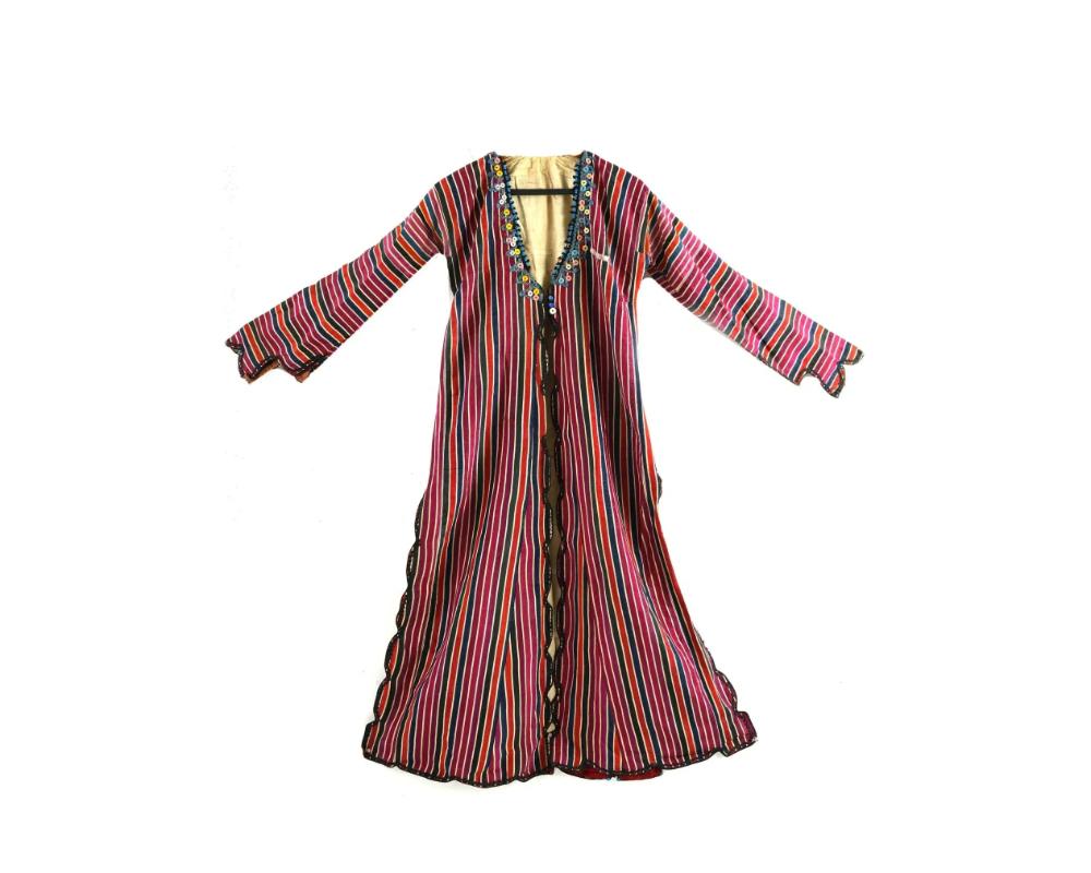 An antique Turkish Ottoman hand crafted silk womens robe. Circa mid to late 18th century. The robe is hand crafted and decorated with vertical stripes in a warm color scheme. The wavy edges are finished with black knitted thread and tape. Somewhere,