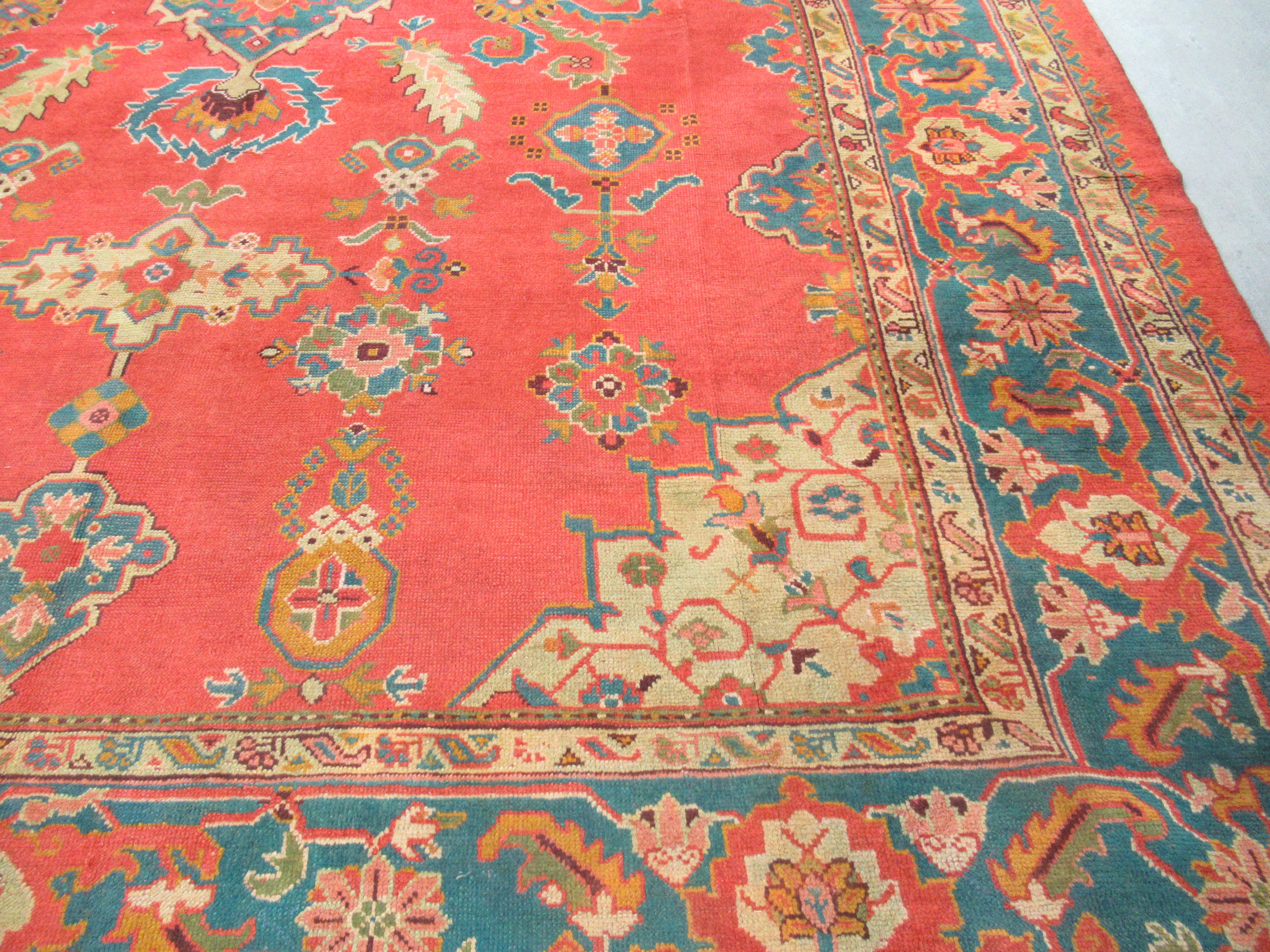 Antique Turkish Oushak carpet of outstanding colour with a small medallion design.
A truly outstanding late 19th century Oushak carpet, the traditional small medallion design is on a very soft warm red ground, the design in soft pastel colours