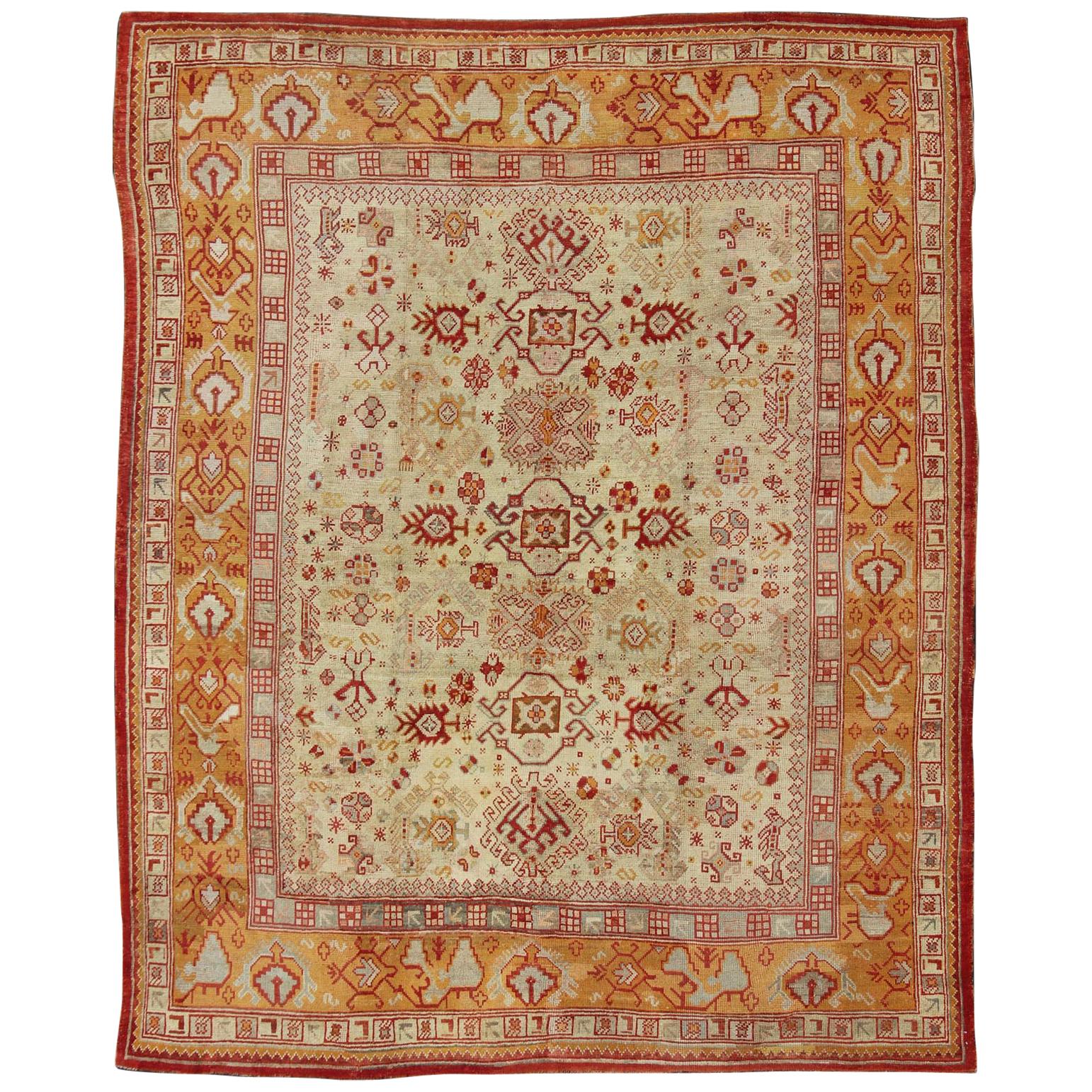 Tapis turc ancien d'Oushak avec motifs sur toute sa surface en rouge, taupe et orange