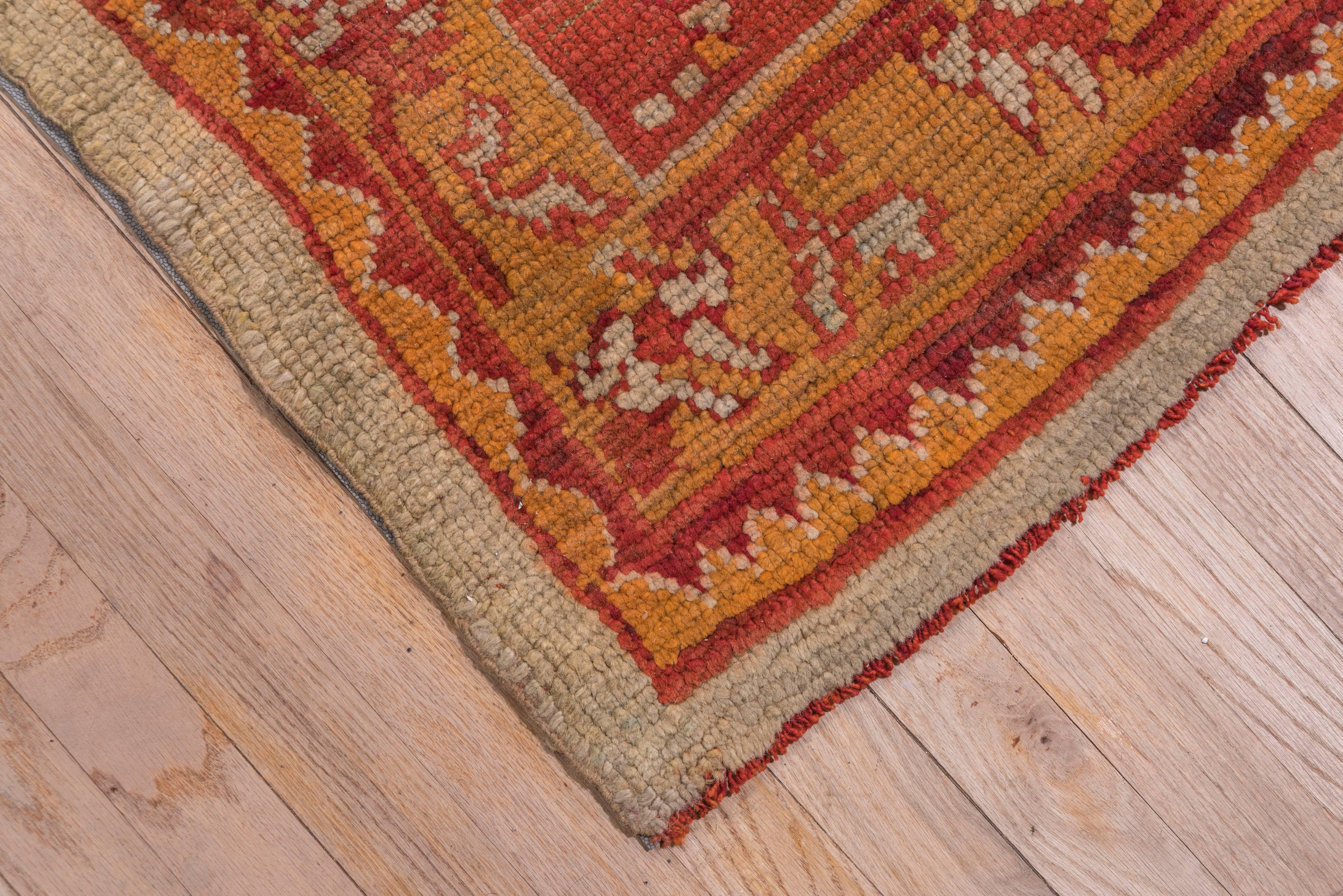This west Anatolian workshop carpet retains some of its classical forebears with its oval, flamed-edged oval ivory medallion and arabesque defined ivory corners. The orange-gold tracery on the pale green ground also traces back to early ottoman