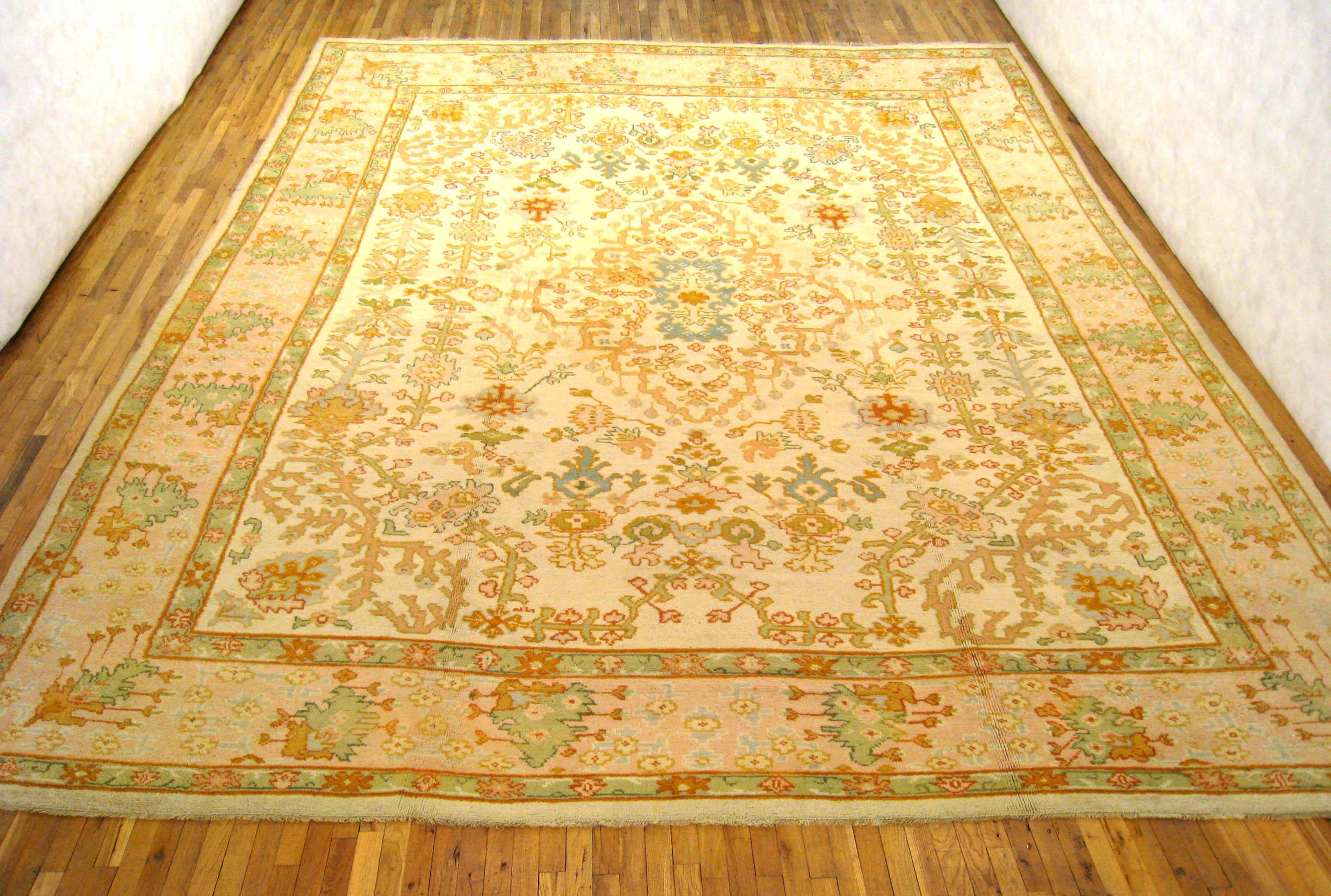 A gorgeous antique Turkish Oushak carpet, circa 1900, size 15'8 x 13'1. This lovely carpet features an unusual design in the ivory central field, characterized by floral blossoms, vines, and trellis motifs, with the result being delightful, but not