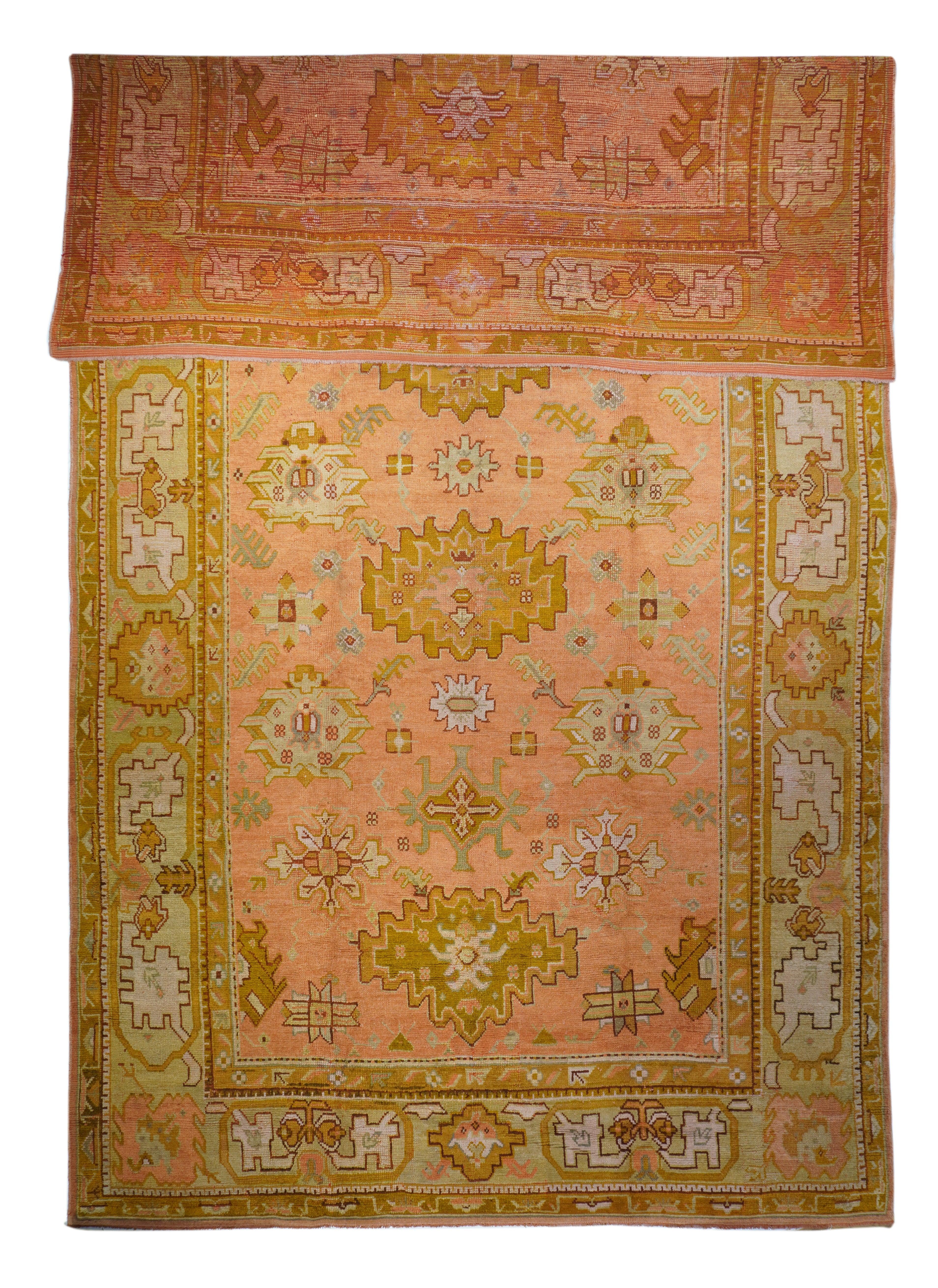 Antique Oushak Rug 10'5'' x 18'10''. The buff field displays a rather spacious layout of convex marigold ashiks, straw secondary symmetrized palmettes, rust corner partial leaves and sandy tertiary elements. The straw-yellow border shows fringed