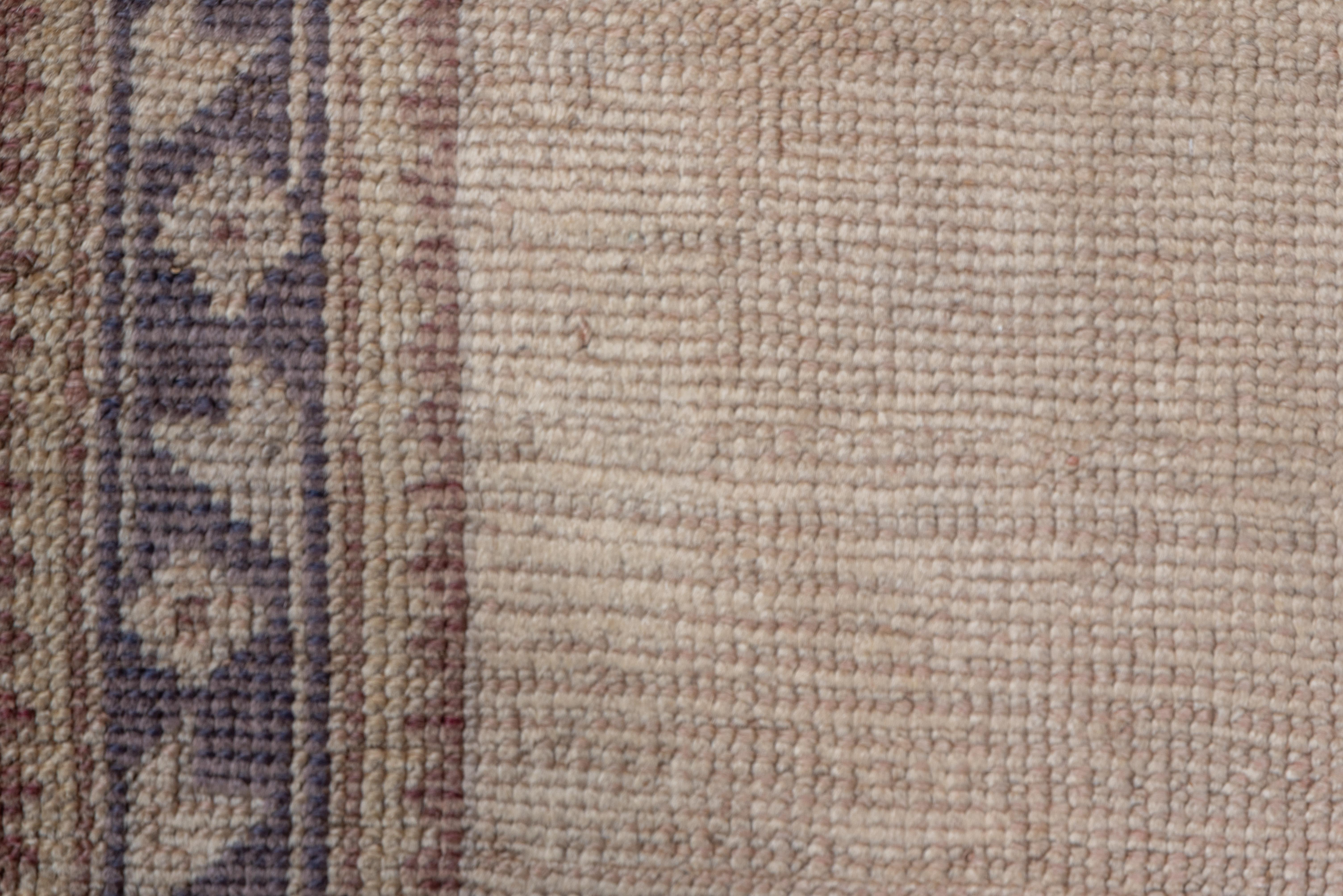 The totally plain eggshell field is framed by a narrow border system. The skinny main stripe shows leaves and diamond florets. Wool foundation, coarse weave. Good condition. Unusual size.
 