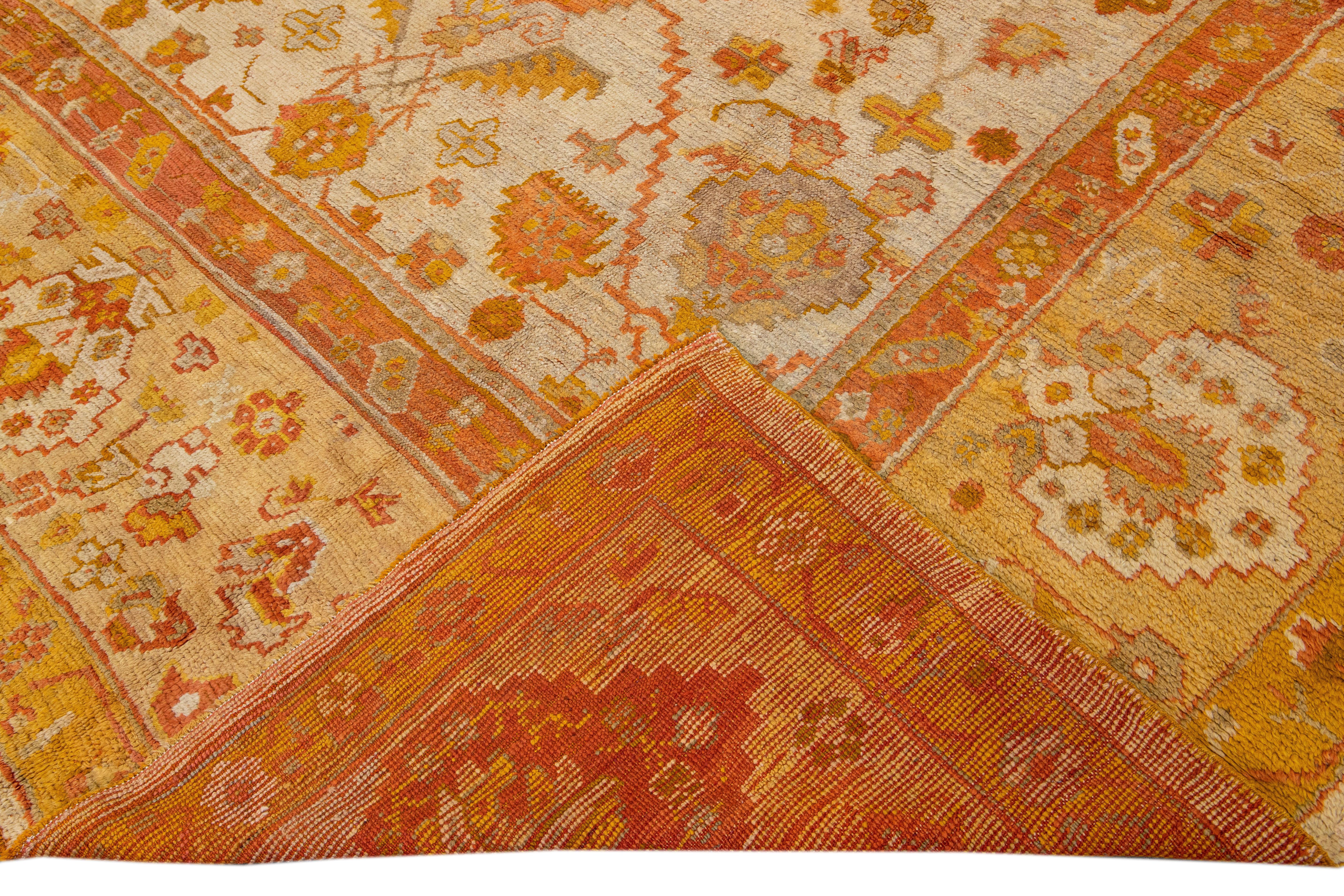 Beautiful Vintage Turkish hand-knotted wool rug with a beige field. This rug has a designed goldenrod frame with accents of orange and gray in a gorgeous all-over floral design.

This rug measures: 11'9