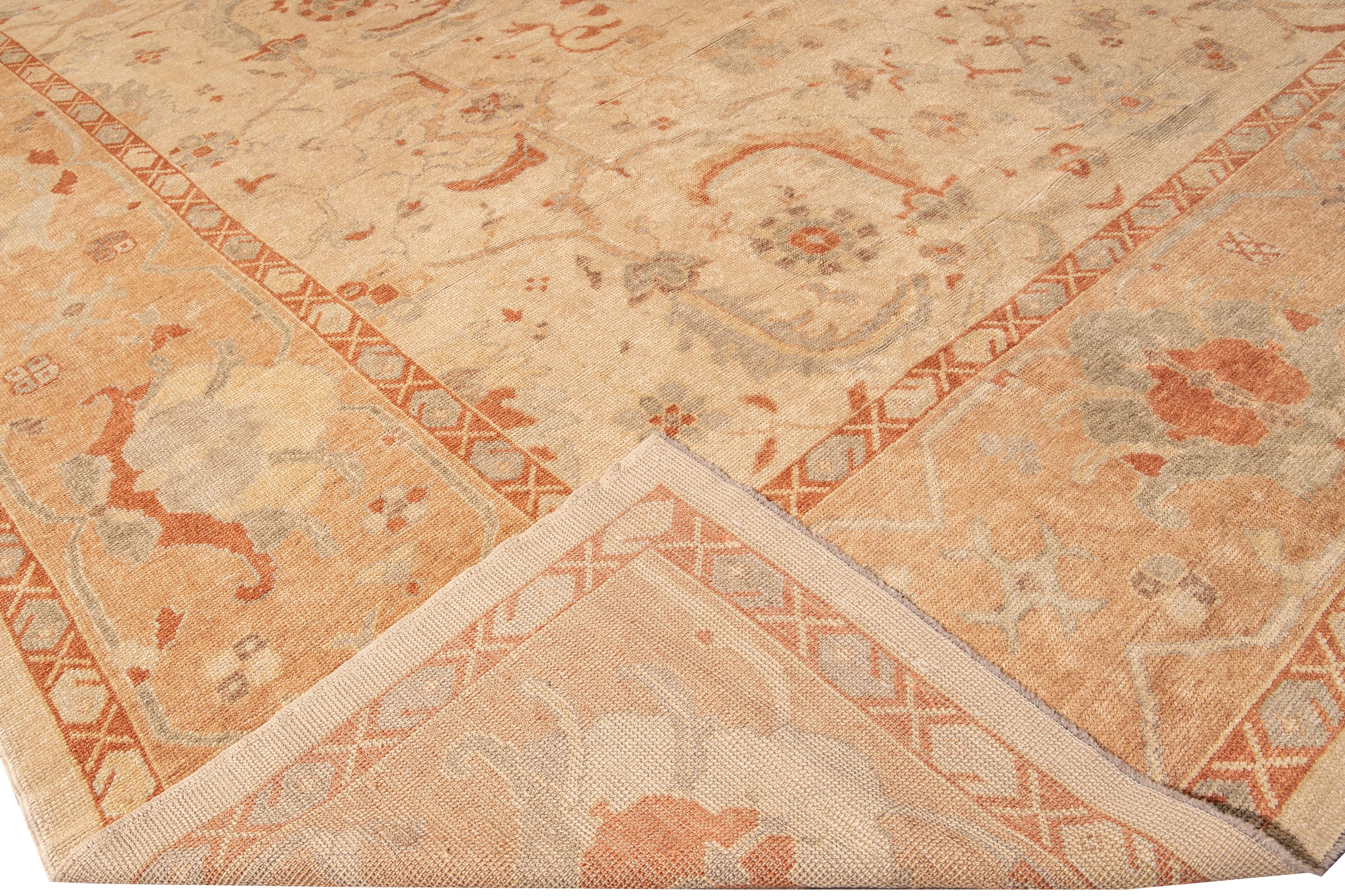 Beautiful antique Turkish Oushak hand-knotted wool rug with the beige field. This Oushak rug has a peach frame gray, orange, and ivory accents in a gorgeous all-over center medallion floral design.

This rug measures: 14'5