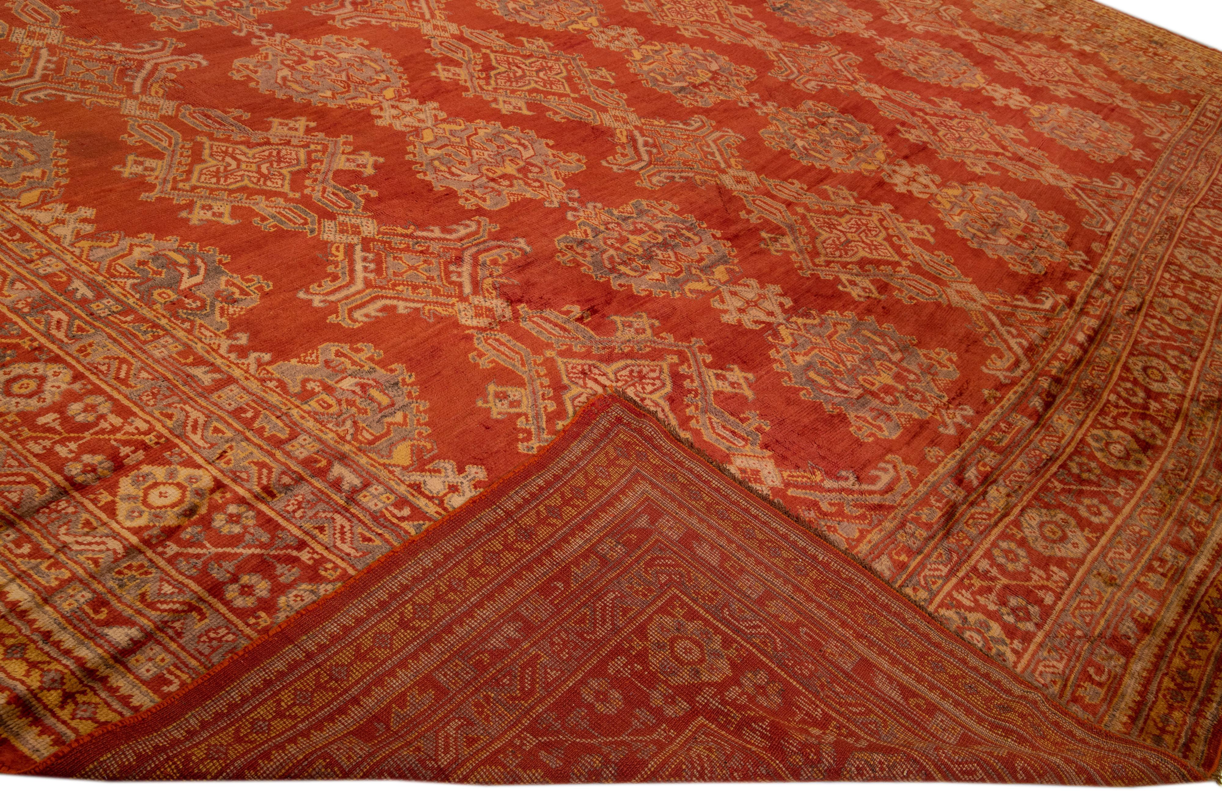 Schöner türkischer handgeknüpfter Wollteppich im Vintage-Stil mit einem orange-rostfarbenen Farbfeld. Dieser Teppich hat einen gestalteten Rahmen und graue Akzente in Goldrute und Braun in einem wunderschönen, geometrischen Blumenmuster.

Dieser