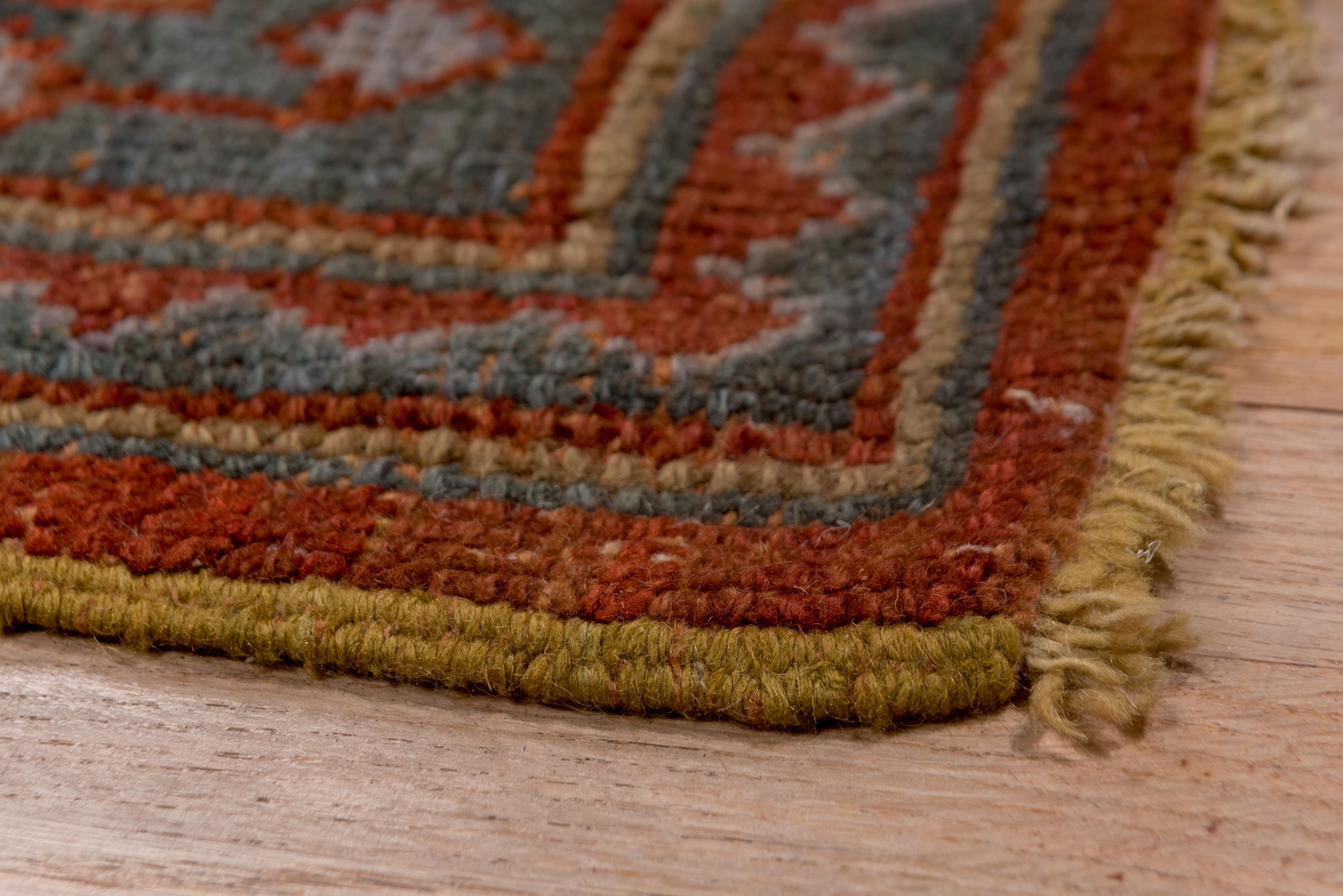 In a modernized ottoman style, this coarsely woven town carpet shows a dotted Turkey rust & orange field supporting a moss green medallion and green corners. Green Zanbaki style border with palmettes and very stylized irises.