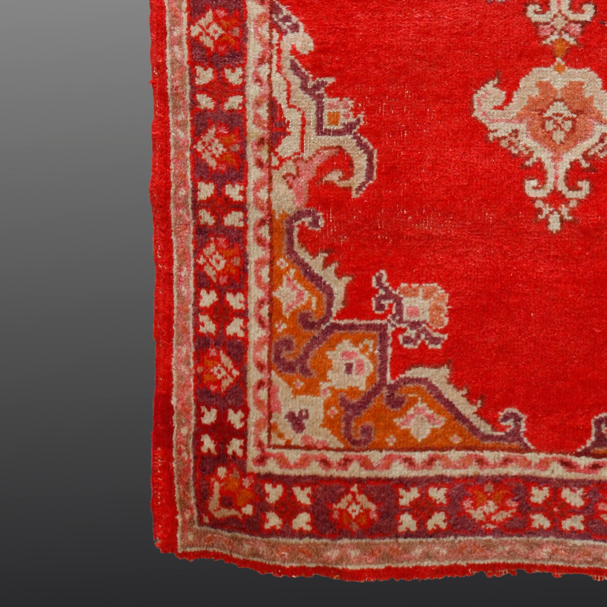 An antique Turkish Oushak Oriental rug offers wool construction with central star medallion on red ground having ornate scroll and foliate spandrels, circa 1920

Measures: 69