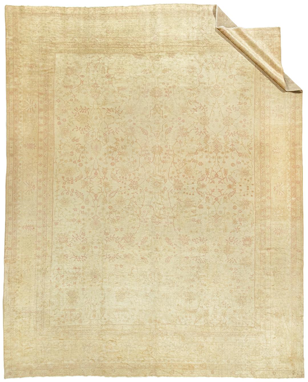 Antique Turkish Oushak rug, 13' x 16'. Delicate botanical patterns woven in soft rose and creams cover the central field on this antique Oushak rug from Turkey. A border of palmettes and repeating floral patterns is surrounded by four floral