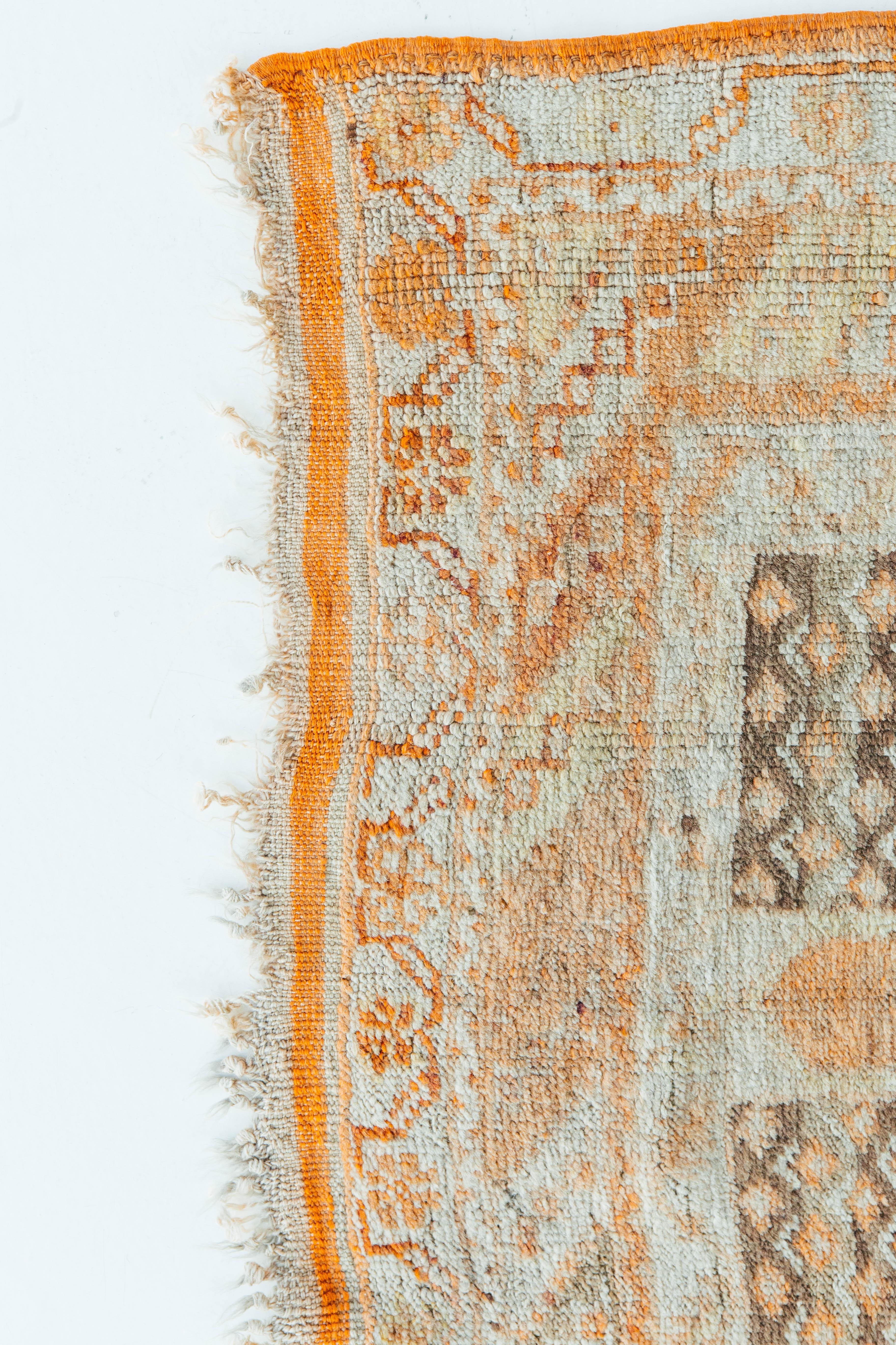 A vibrant and interesting antique Turkish Oushak rug. This piece contains a central medallion with surrounding tribal patterns in saffron, vintage blue, and hints of gray. Suitable for a wide variety of interiors and is sure to bring character to