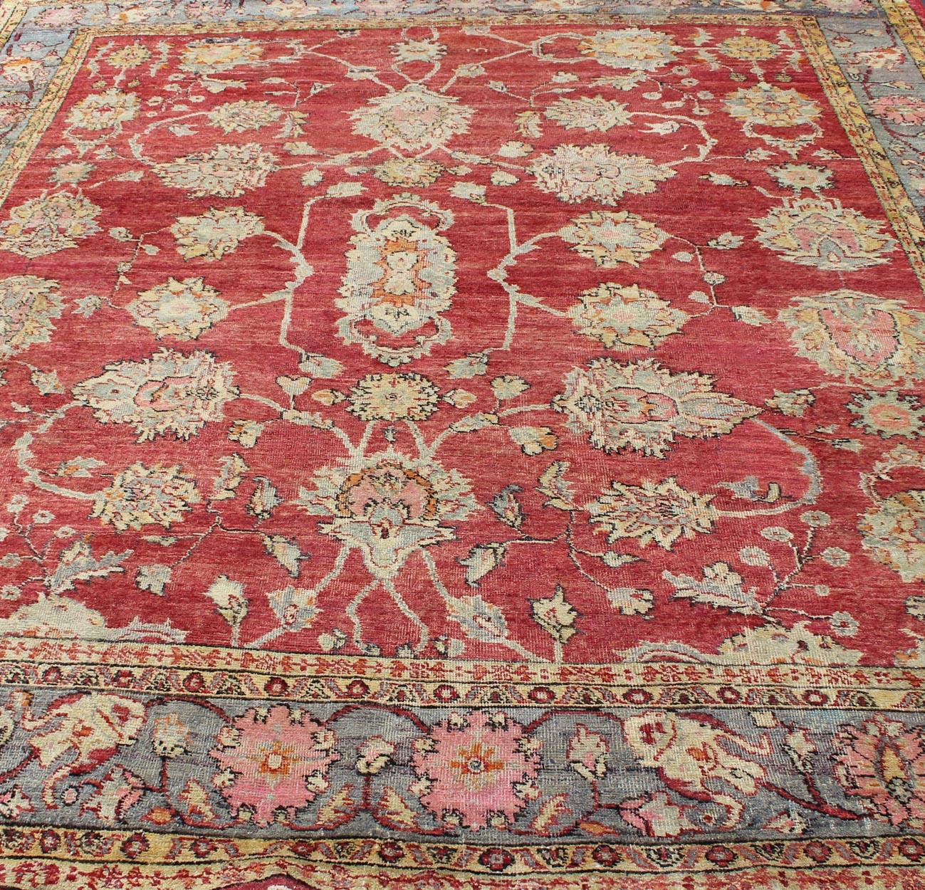 Early 20th Century Antique Turkish Oushak Rug in Red, Blue/Gray Border, L. Green, Yellow & Pink For Sale