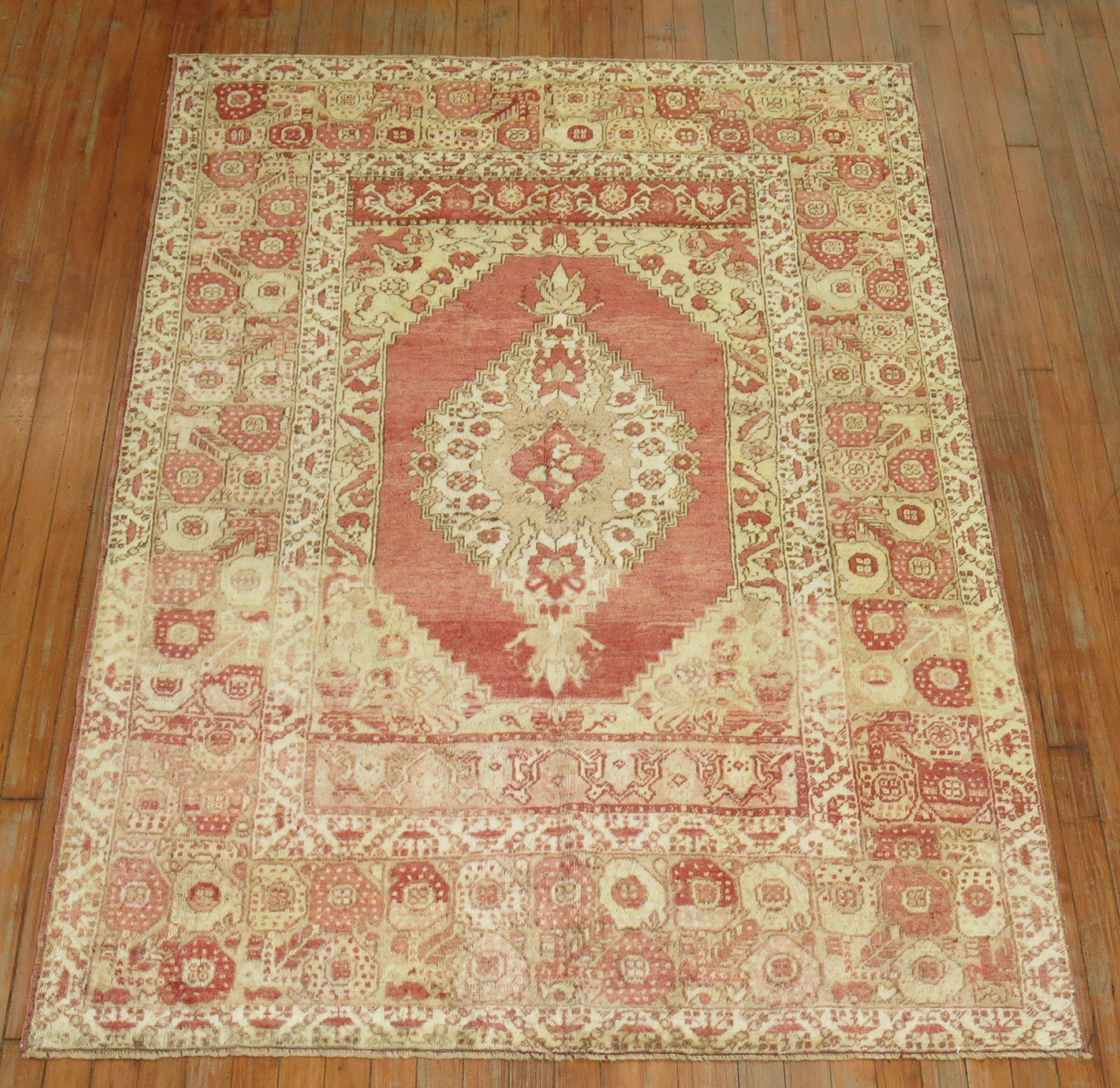 Turkish Oushak rug with a traditional medallion border design in melon red, brown and ivory accents, circa 1920.

Measures: 4'5