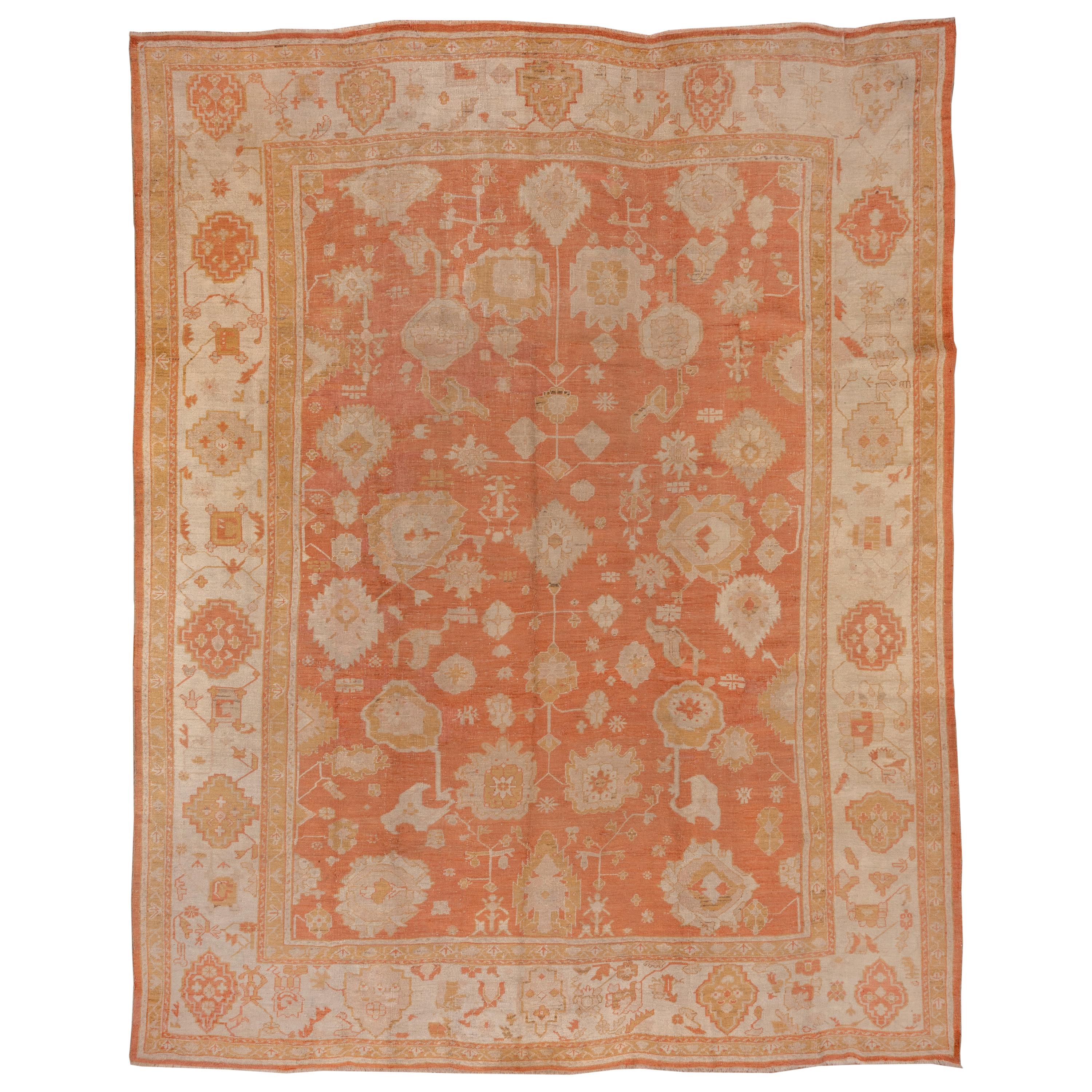 Tapis turc ancien d'Oushak, terrain orange sur toute sa surface, bordures ivoire, vers 1900