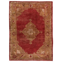 Tapis turc ancien d'Oushak, champ rouge et bordures dorées, médaillon central