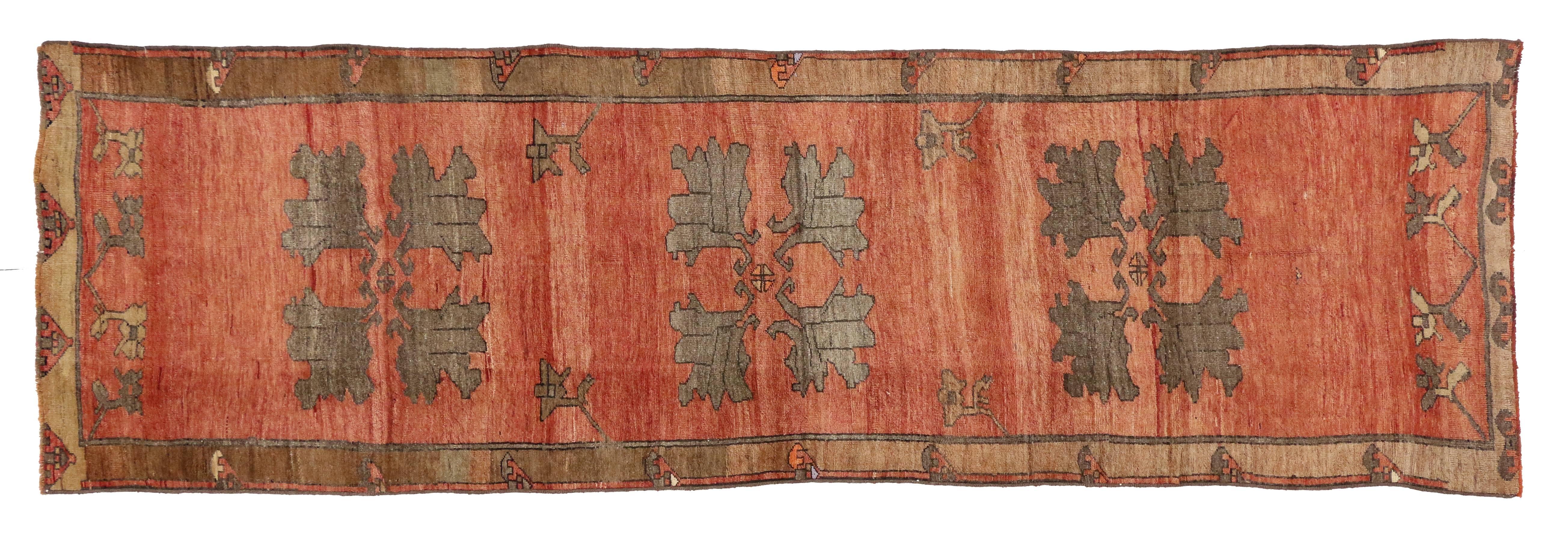 50188, an antique Turkish Oushak rug runner in traditional style. This luxurious Oushak runner features three lush palmettes with angular petals in taupe-slate and cloudy grey on an abrashed red field. The vintage Oushak runner is bordered in a