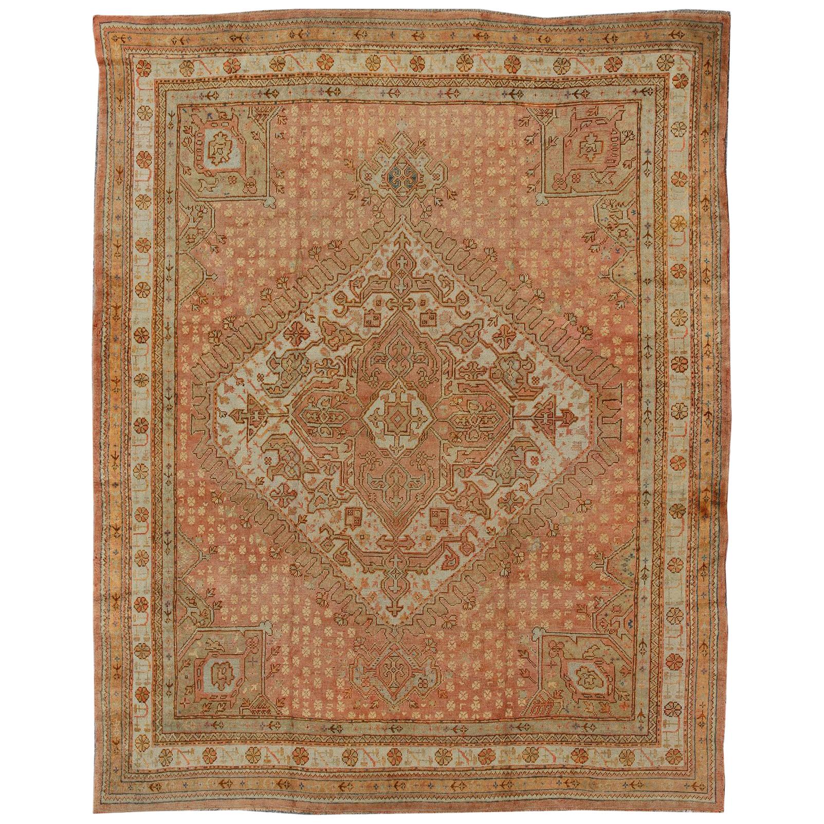 Antique Turkish Oushak Rug with Geometric Medallion in Salmon Background For Sale