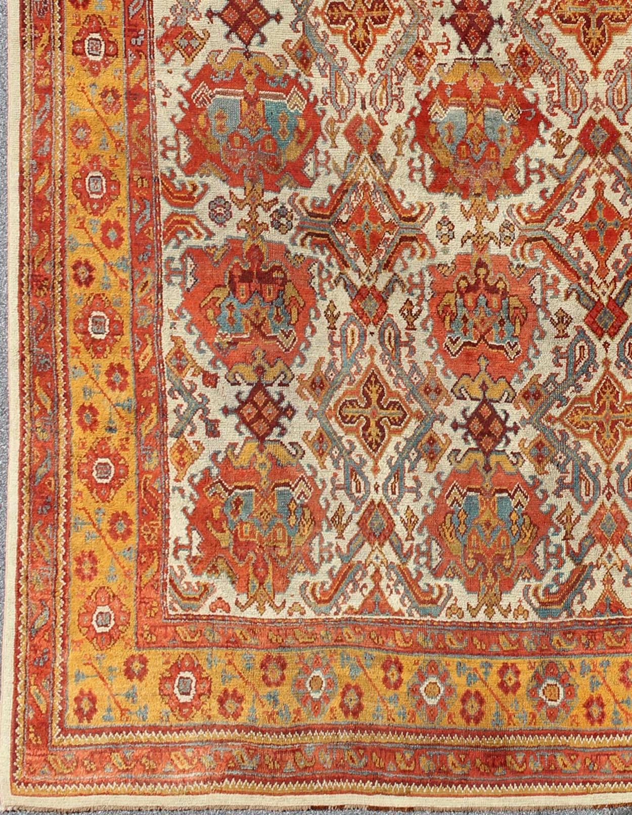 Antique Turkish Oushak Rug with Multi-Medallions in Ivory, Orange, Red & Blue  and gray,. Keivan Woven Arts / rug 17-0202, country of origin / type: Turkey / Oushak, circa 1900

Measures: 11'10 x 17'8.  

This antique Turkish Oushak rug features an