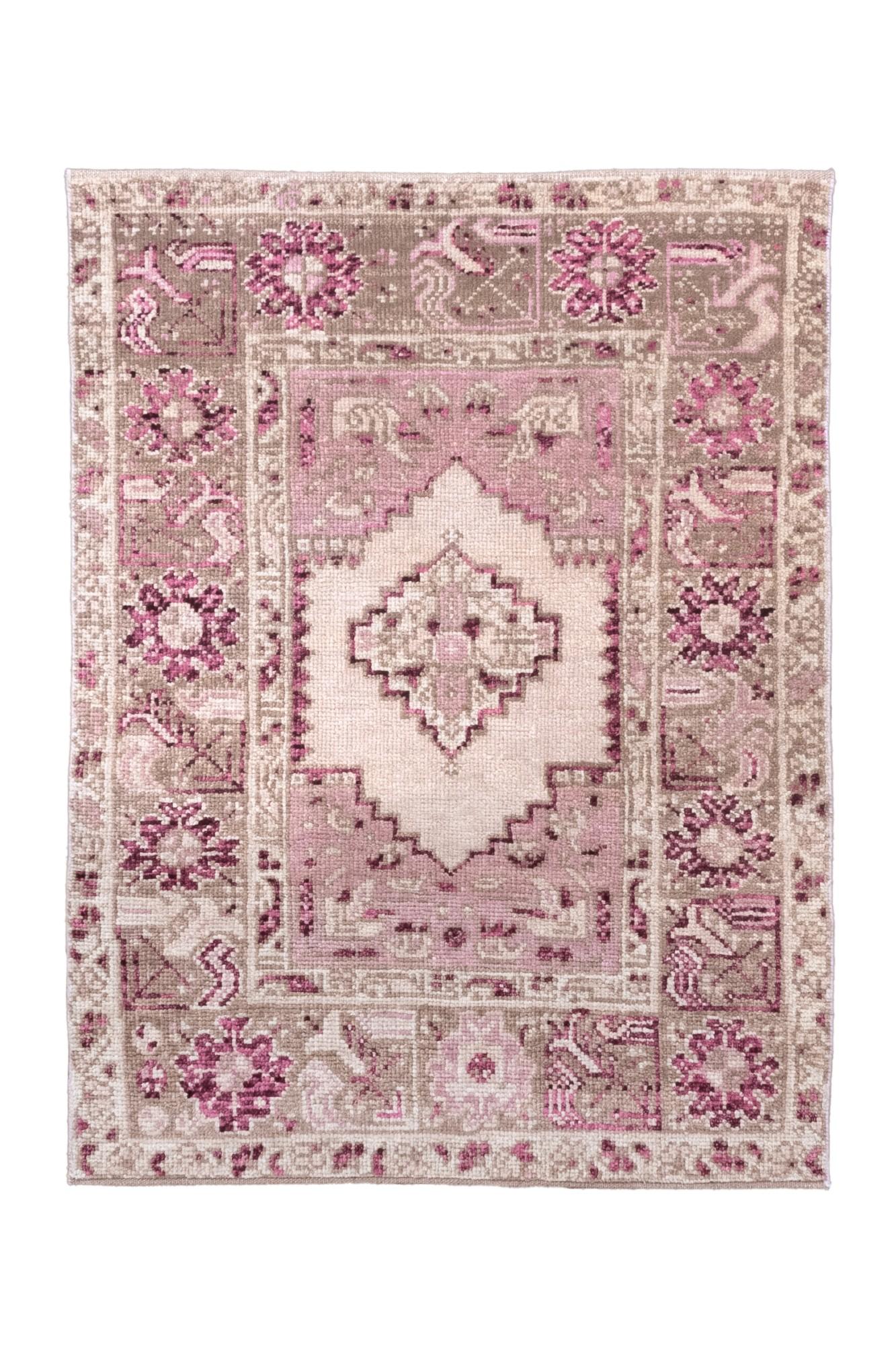 Dieser bezaubernde antike Oushak-Teppich, der um 1920 in der Westtürkei gewebt wurde, zeigt eine zarte Palette von rosa-, lavendel- und taupefarbenen Tönen. Durch sein kleines Format eignet er sich perfekt als Akzentteppich oder als dekorativer