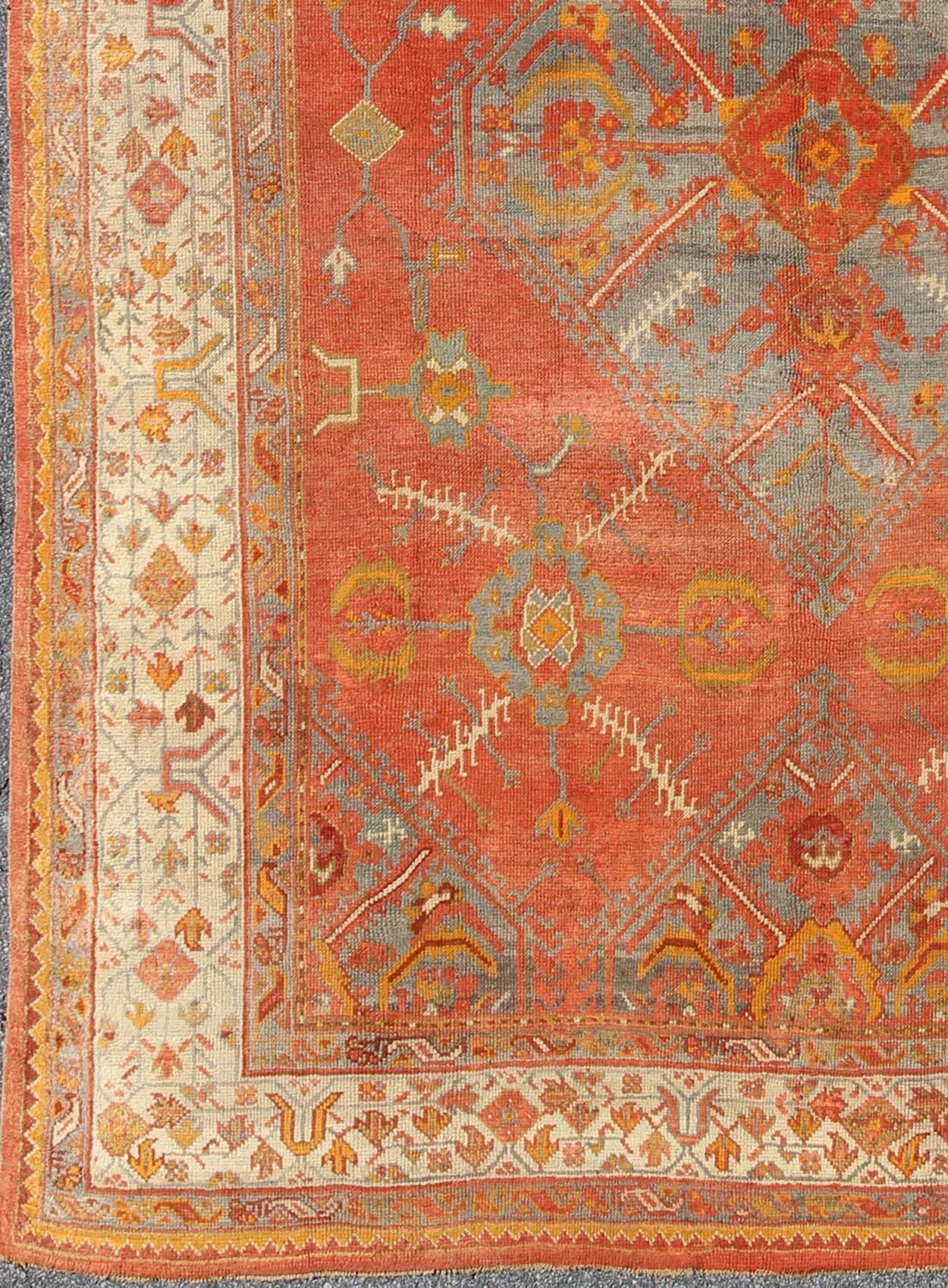 Antique Turkish Oushak rug with tribal Medallion design in terracotta, light gray blue, ivory and gold. Keivan Woven Arts /  rug 16-0911, country of origin / type: Turkey / Oushak, circa 1900
Measures: 10' x 13'8.
This antique Turkish Oushak carpet
