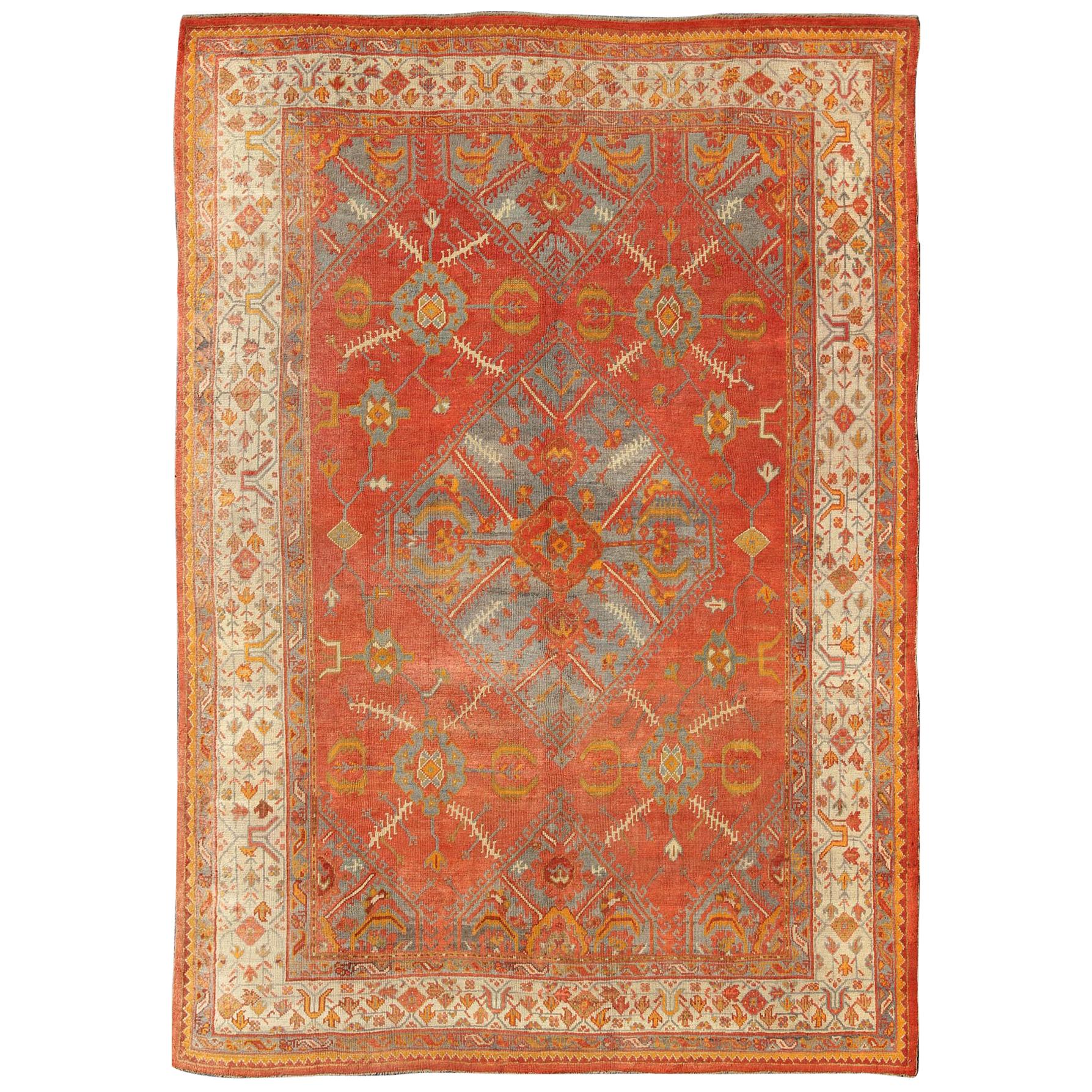 Tapis turc ancien d'Oushak avec motif de médaillon tribal en terre cuite et bleu