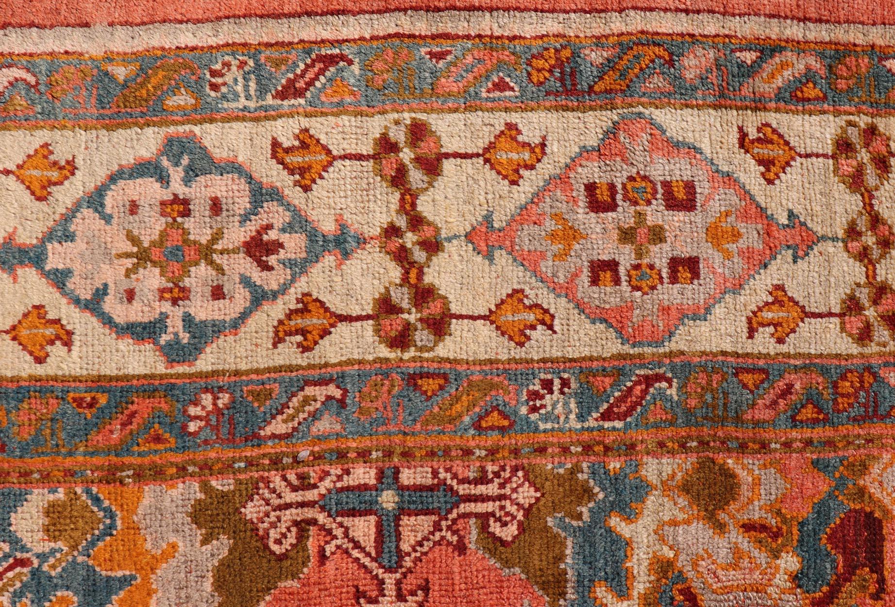 Maße: 10'9 x 14'7 
Antiker türkischer Oushak-Teppich mit warmen Korallen-, Elfenbein- und Teal-Akzenten 10'9 x 14'7. Keivan Woven Arts / Teppich/17-0605, Herkunftsland / Art: Türkei / Oushak, um 1910.

Dieser antike türkische Oushak-Teppich zeigt