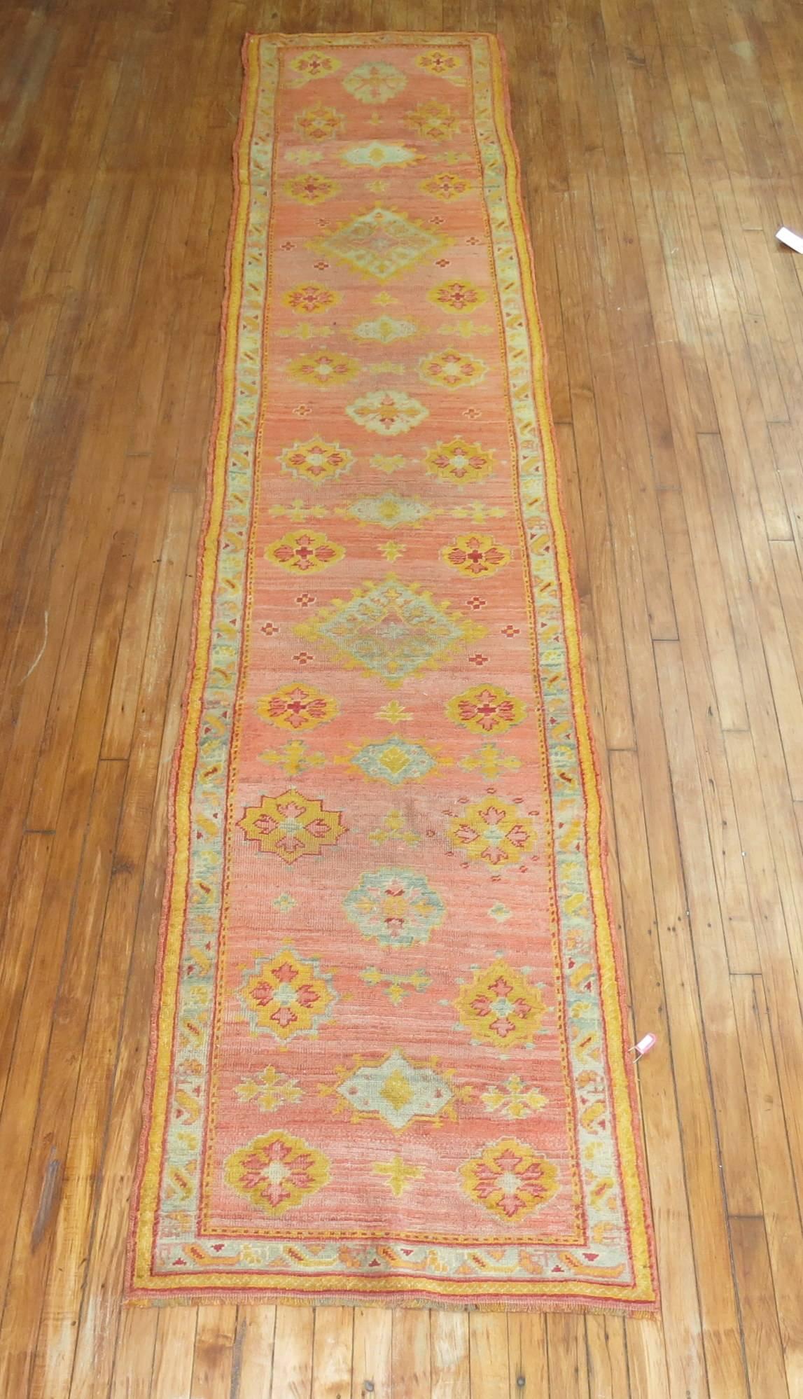 Antique Oushak runner in predominant pinks and corals.