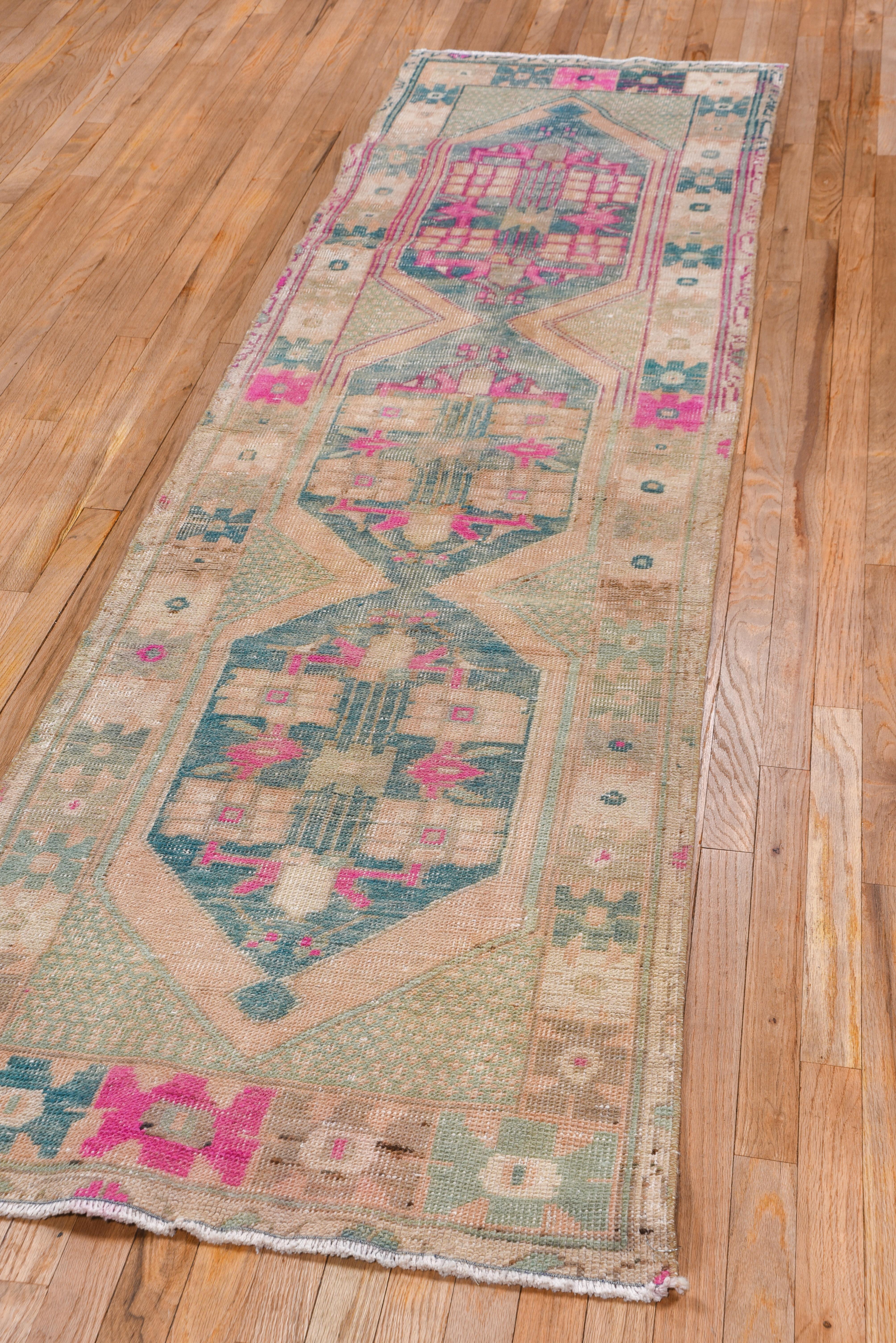 This Turkish oushak runner has three stretched hexagons that are joined to form a pole medallion on as sandy straw ground, while enclosing small square ornaments, and framed by a geometric border of six pointed winged motives.