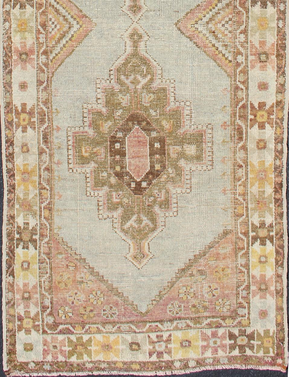 Coral, ice blue, brown and olive-toned Oushak runner from Turkey, rug tu-TRS-136583, country of origin / type: Turkey / Oushak, circa 1920

This antique Oushak runner from Turkey features three layered medallions spread across its center field,