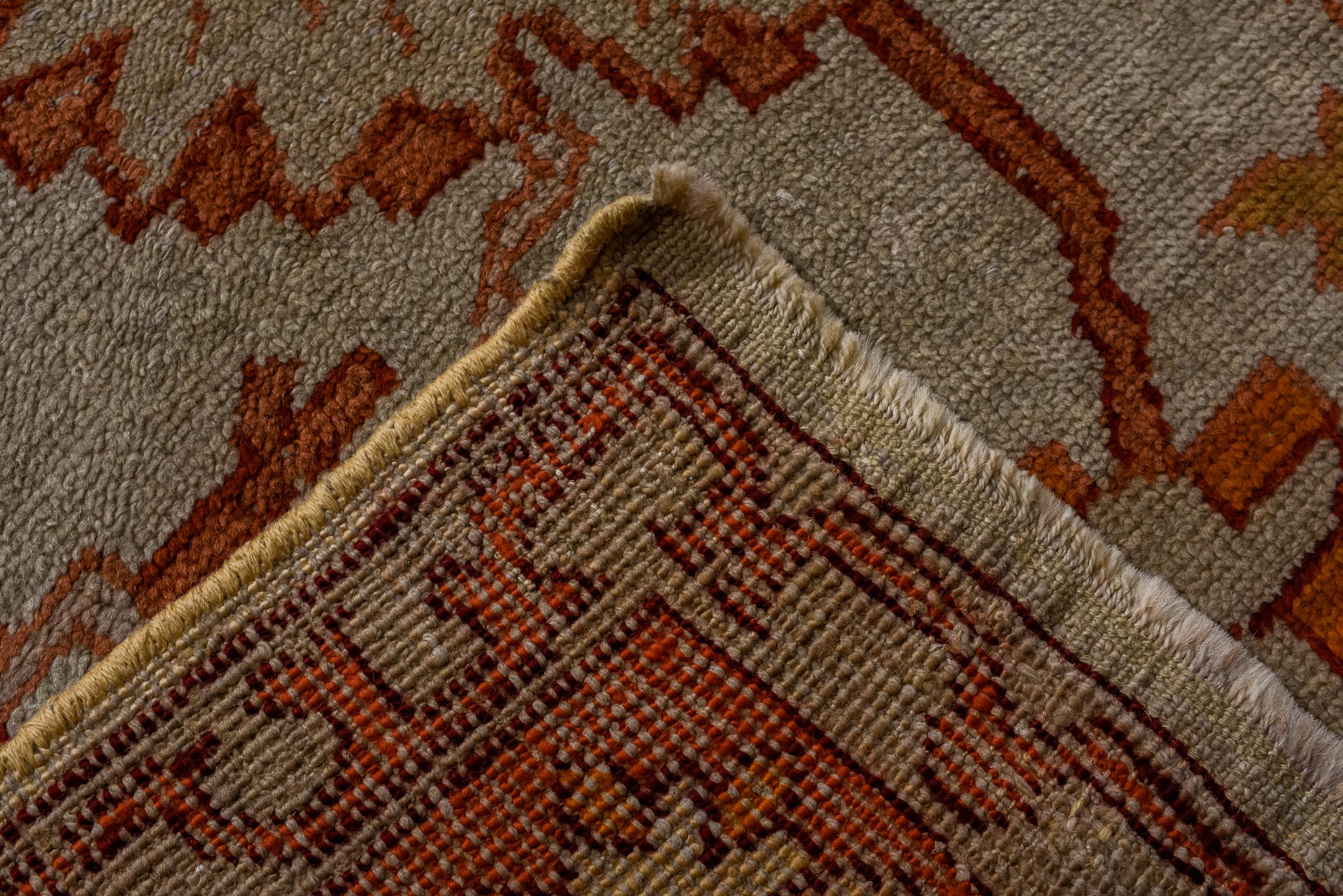 Wool Antique Turkish Oushak with Beige Field and an Allover Palmette Design For Sale