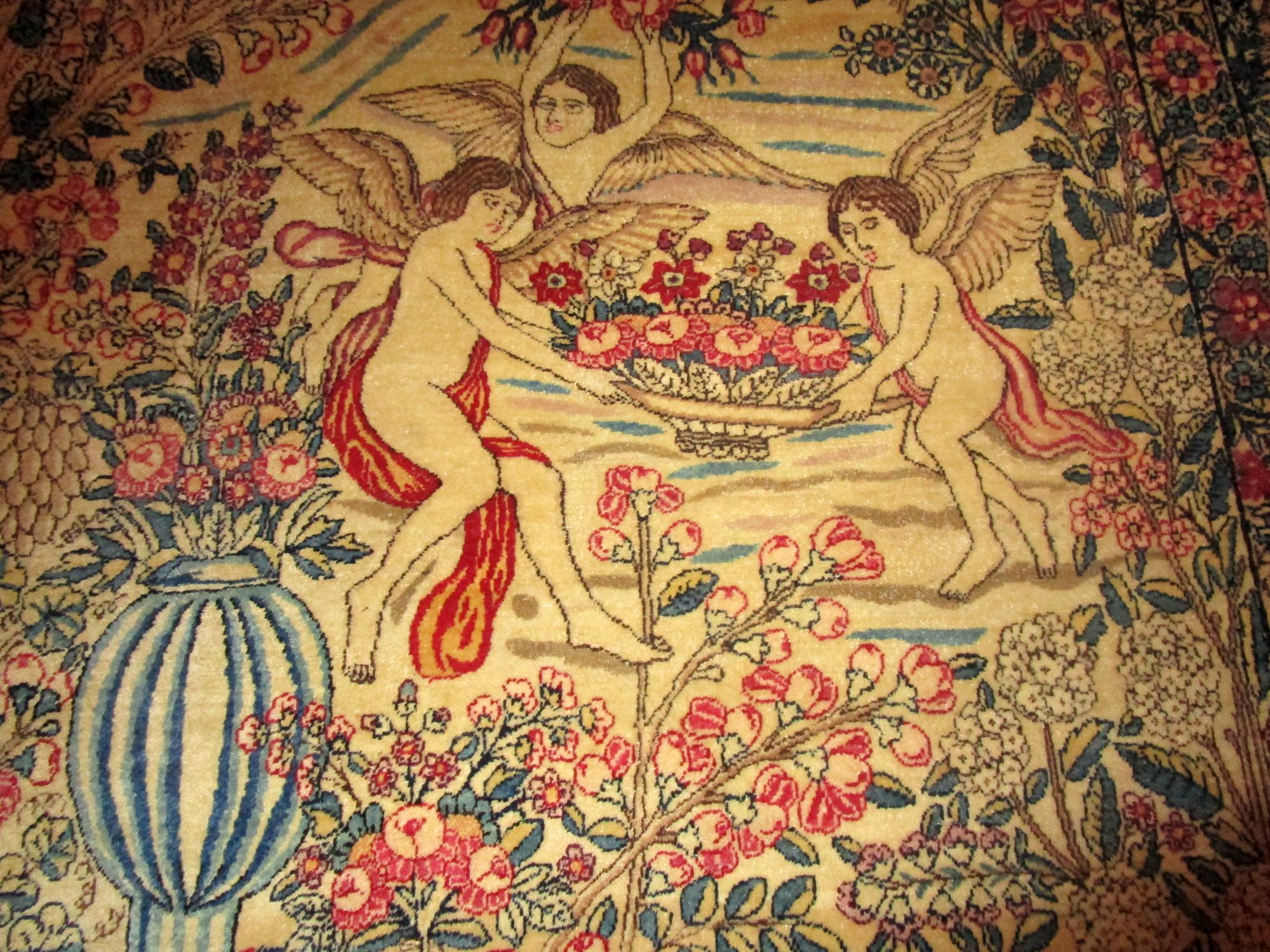 This antique pictorial rug has all the bells and whistles. The two central figures featured are a woman and a flute player gathered around a shrine. The detail and color are incredible with a man's portrait in each corner and flowers, garlands,