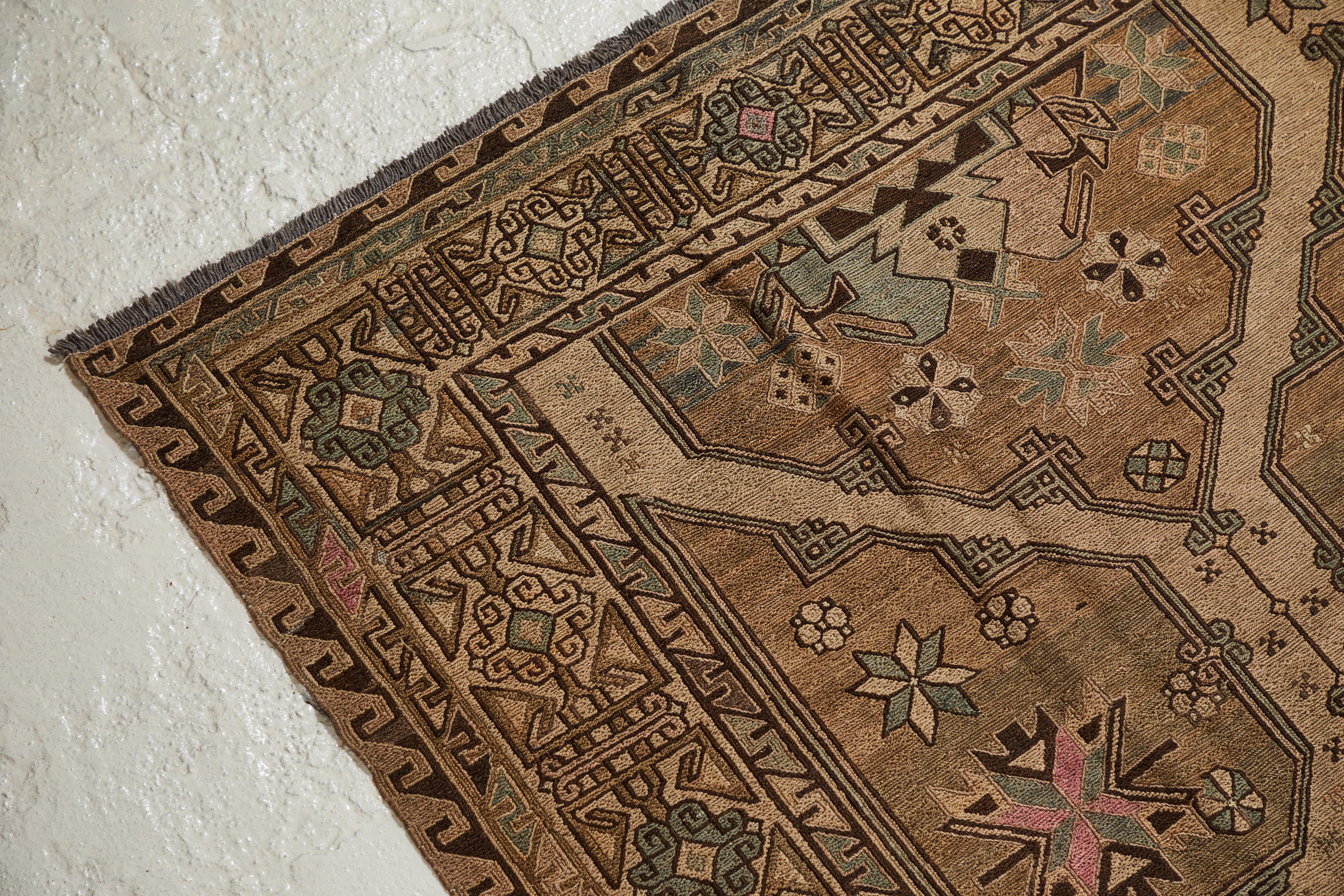 Beautifully detailed antique Turkish rug with a traditional pattern. The rug offers hues of natural, light pink and light green. The rug is beautifully aged and worn.