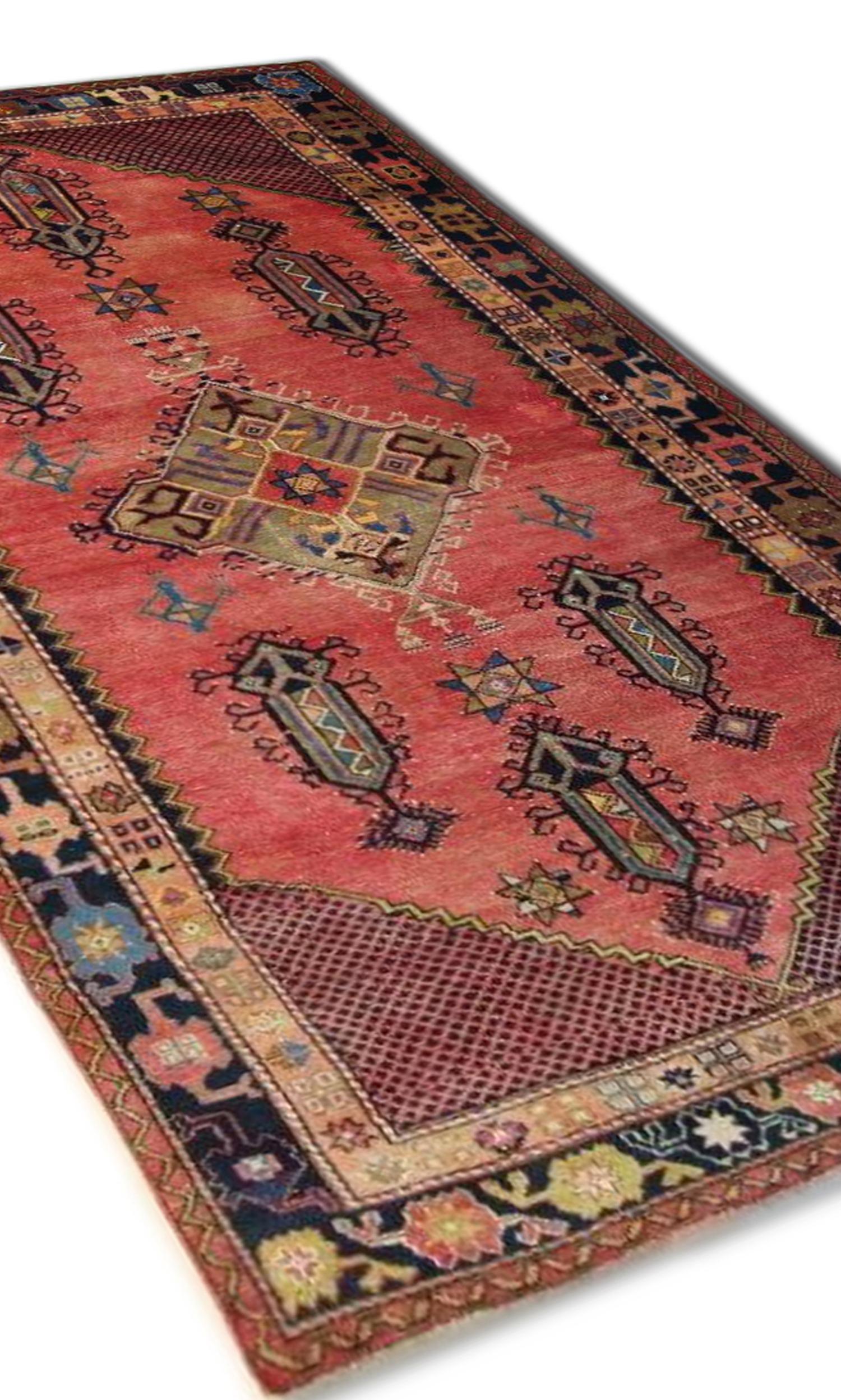 This beautiful antique Turkish rug features a vibrant rust field that holds a large central medallion and six smaller surrounding medallions, intricately woven in accents of blue, red and brown. The highly detailed border encloses this design with