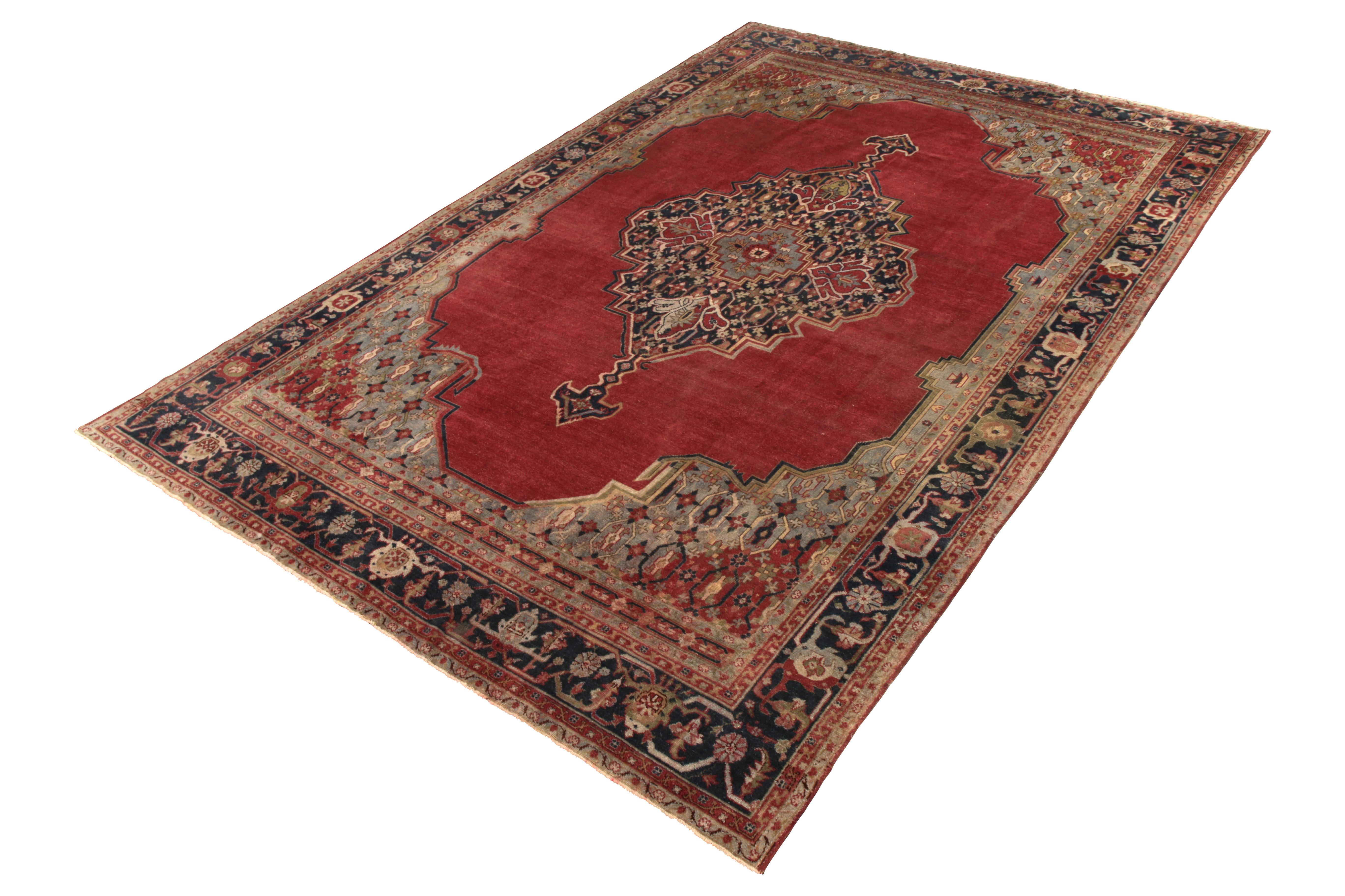 Handmade with hand knotted wool originating from Turkey circa 1890-1900, this item is an antique rug enjoying an influence from transitional Sparta rug traits, as well as a fabulous play of red and blue in a naturally arresting medallion style