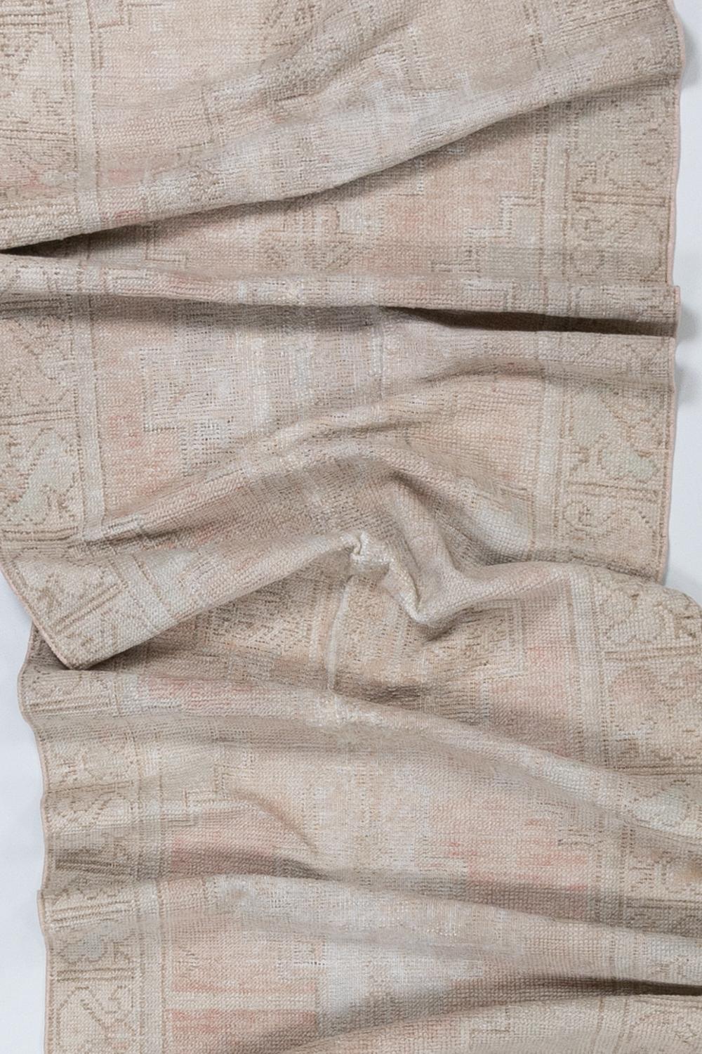 Age: 1930

Colors: soft pale peach, ivory, gray

Pile: low

Wear Notes: 7-8

Material: wool on cotton

Beautiful pale runner with even distressing and a faded colorway.

Vintage and antique rugs are by nature, pre-loved and may show