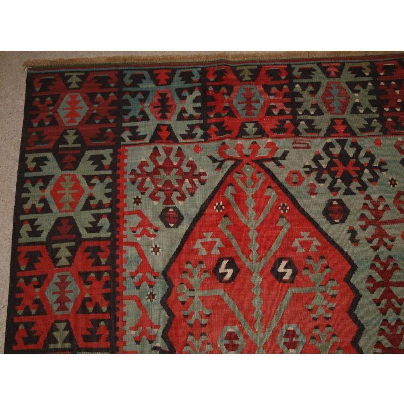Ancien kilim de village anatolien de la région de Sivas, dans le centre-est de la Turquie. Le kilim présente un motif très inhabituel et intéressant représentant un arbre de vie. Tissé avec une superbe gamme de couleurs : rouge doux, bleu indigo