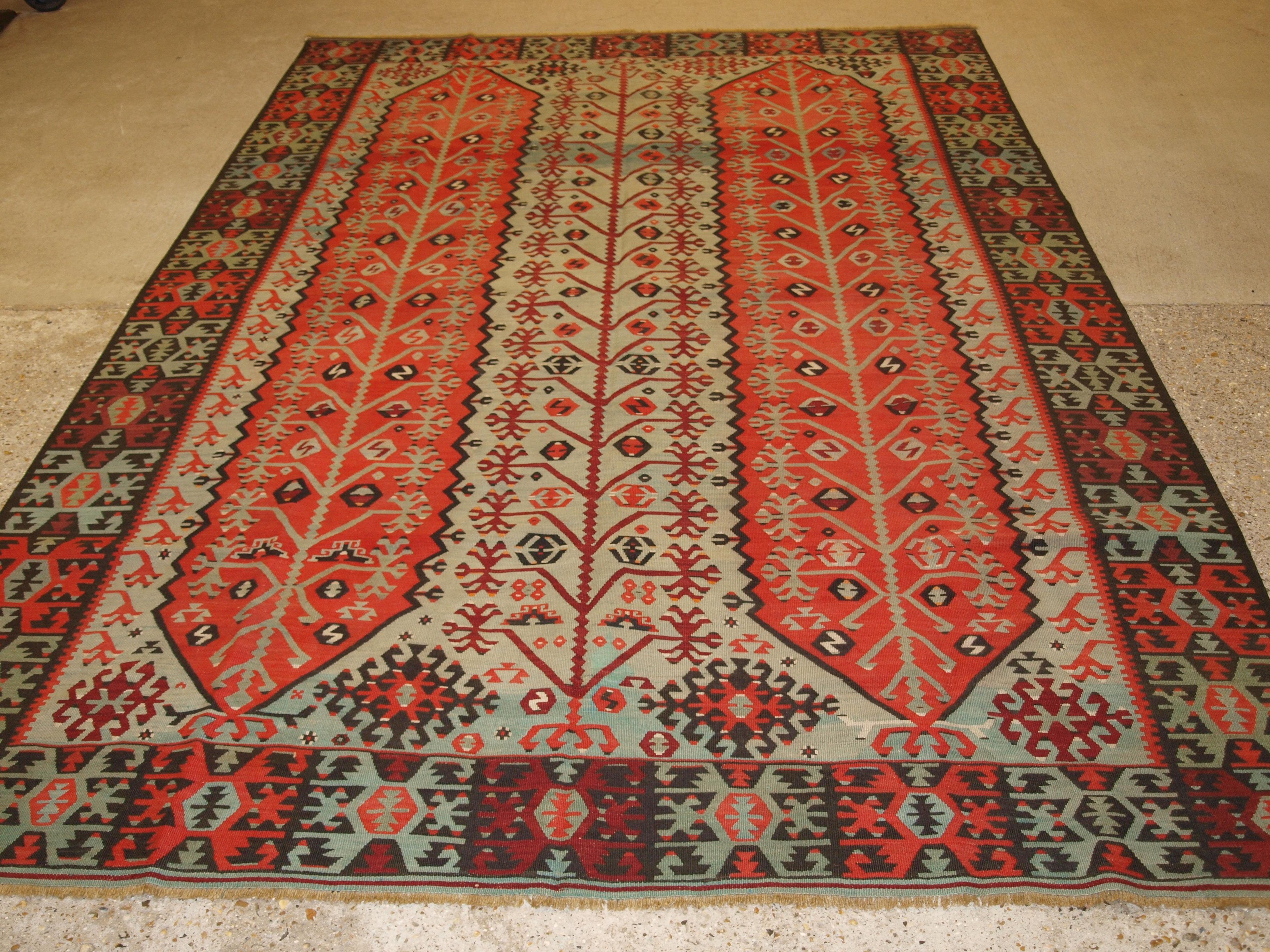 Un ancien kilim de village anatolien de la région de Sivas, dans le centre-est de la Turquie. Le kilim a un design très inhabituel et intéressant avec un arbre de vie. Tissé avec une superbe gamme de couleurs : rouge doux, bleu indigo clair, vert et