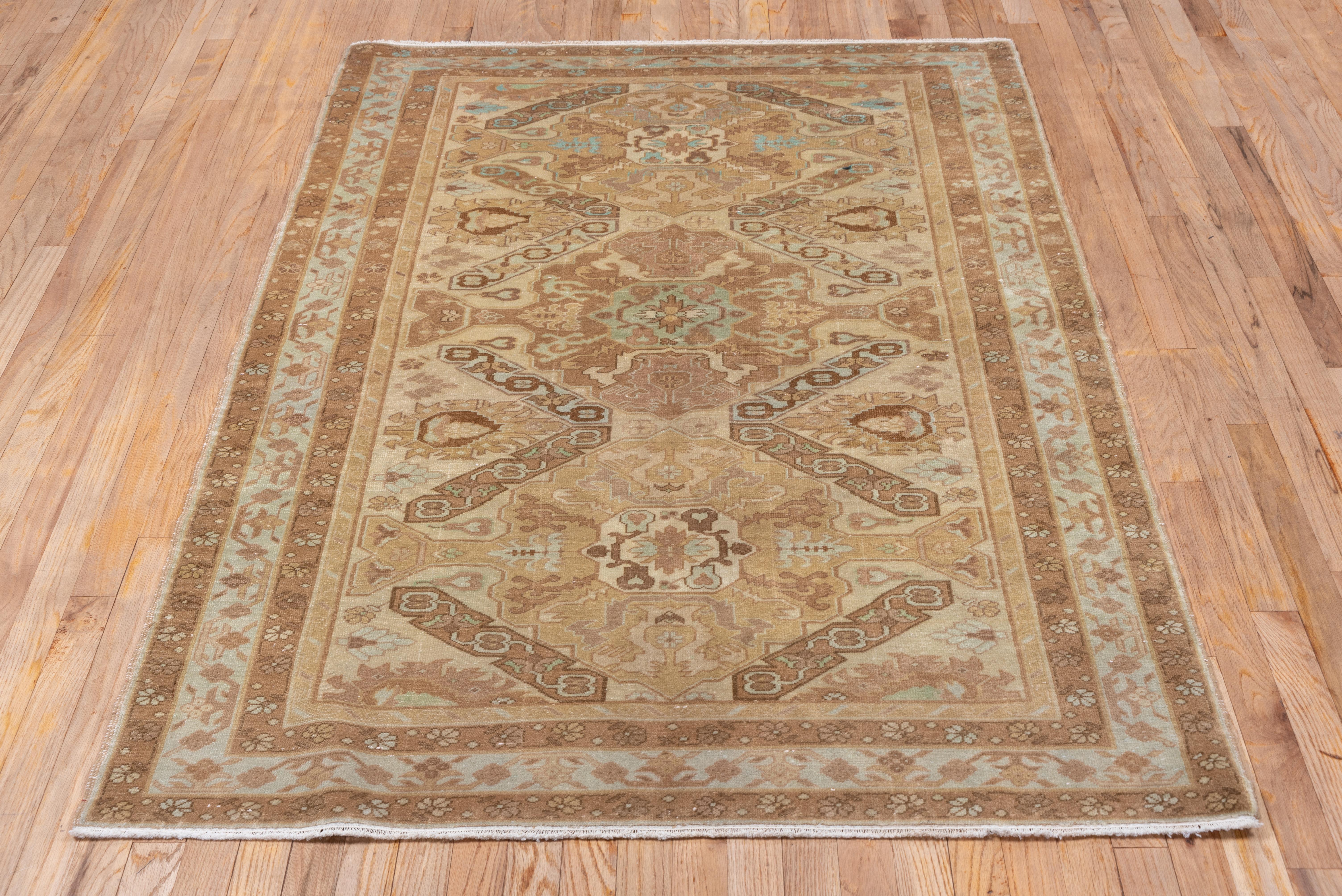 This eastern Turkish city scatter presents a totally Caucasian Kuba pattern of rough palmettes, oblique strips and geometrically lobed medallions, but in mellow tones of beige, rust-brown, pale grey, buff and sienna. The sand main border shows four