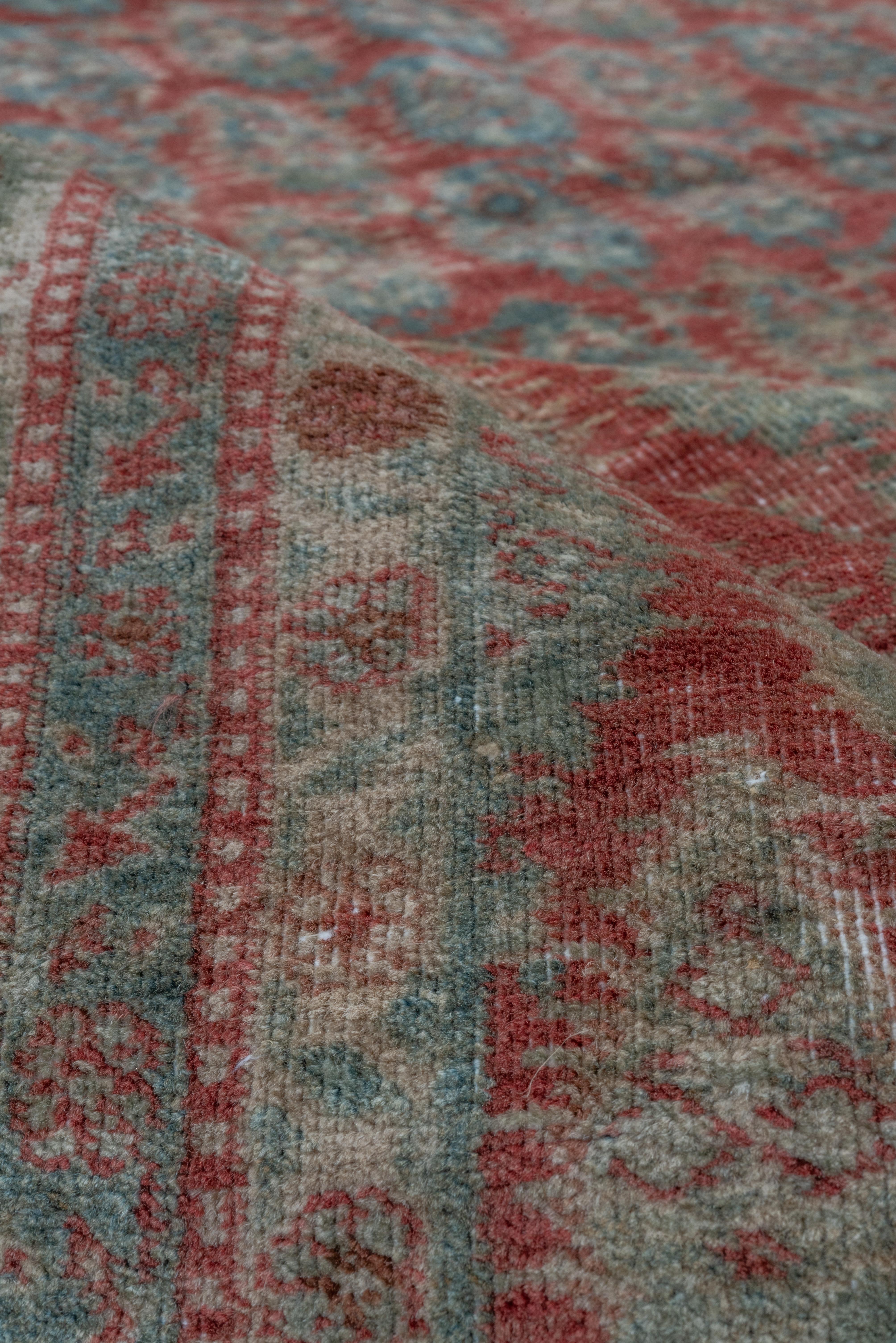 Offset rows of fringed cones closely cover the abrashed rusty-red field of this East Anatolian town carpet in the general Saraband manner. The blue and ivory border features round, serrated rosette flowers and thin vinery. Good condition with