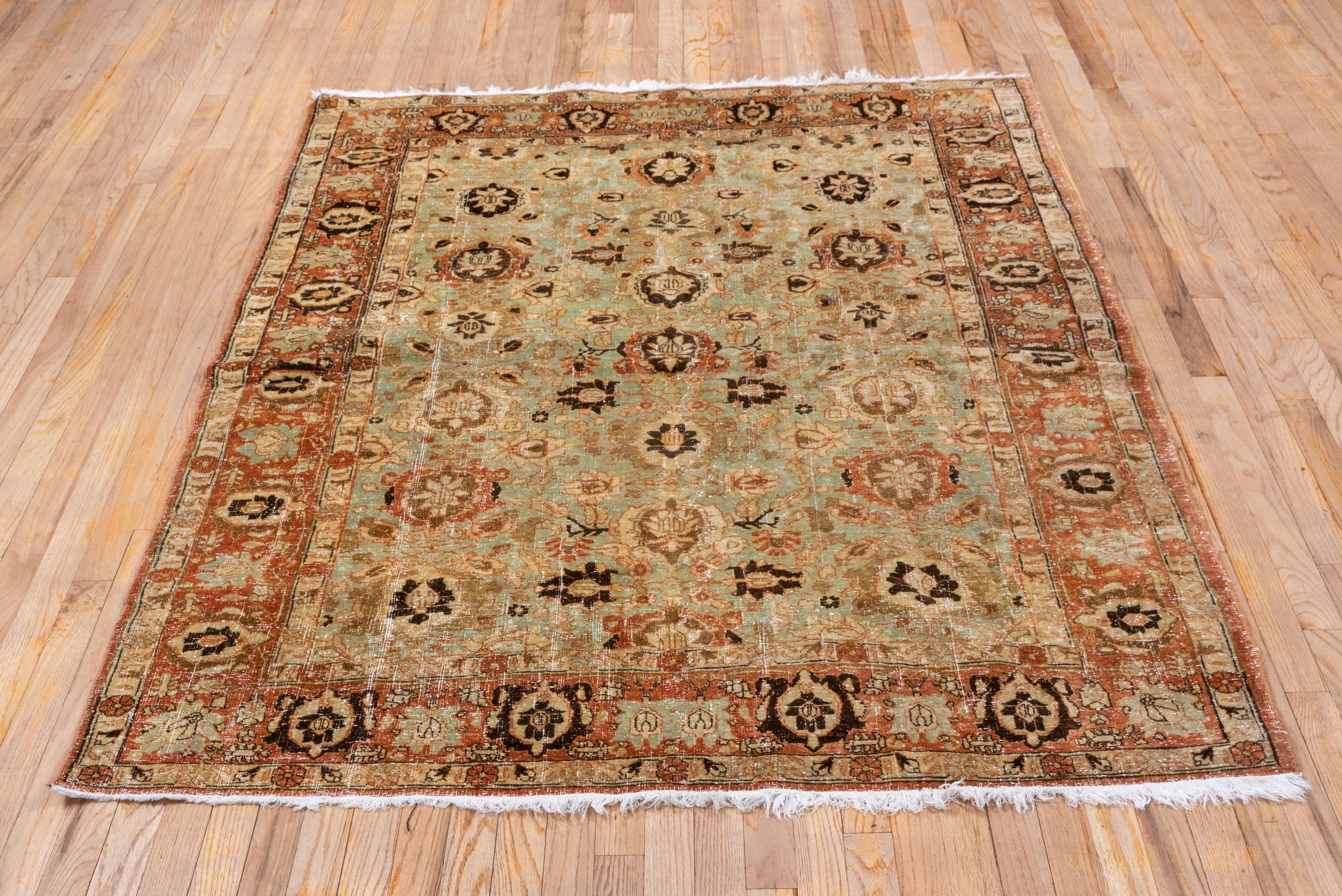 In the Persian Tabriz style with a three column palmette pattern accented in shades of rust, on seafoam field. Two types of palmettes decorate the abrashed rust main border. Medium weave on cotton. Fair condition with general wear exposing white