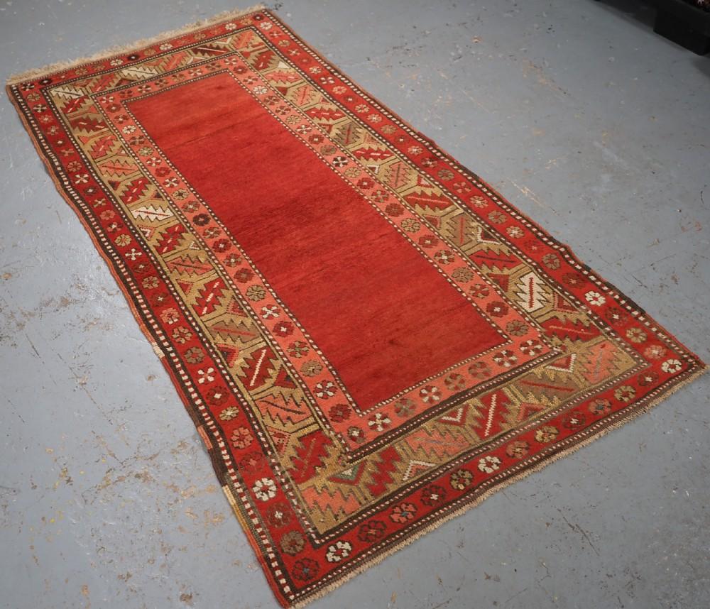 Ancien tapis turc Terekeme Kazak de la région de Kars en Anatolie orientale
Circa 1910

Le tapis a un champ rouge garance uni avec des bandes d'abrasion, les bandes de garde intérieures et extérieures sont un motif de rosette florale, la bordure