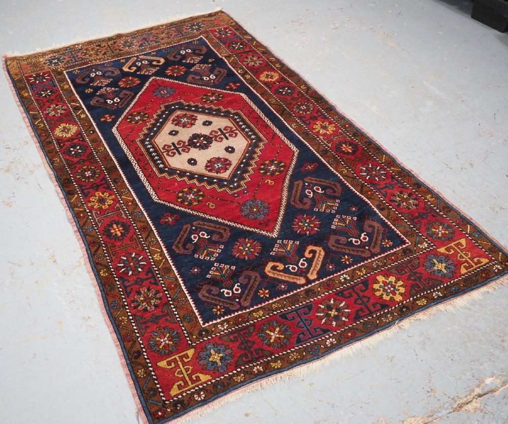 Antique Anatolian Yahyali rug with traditional large medallion design
Circa 1920

A good example of this classic Yahyali design with a single large medallion in warm red on a dark indigo blue ground The field is filled with traditional design