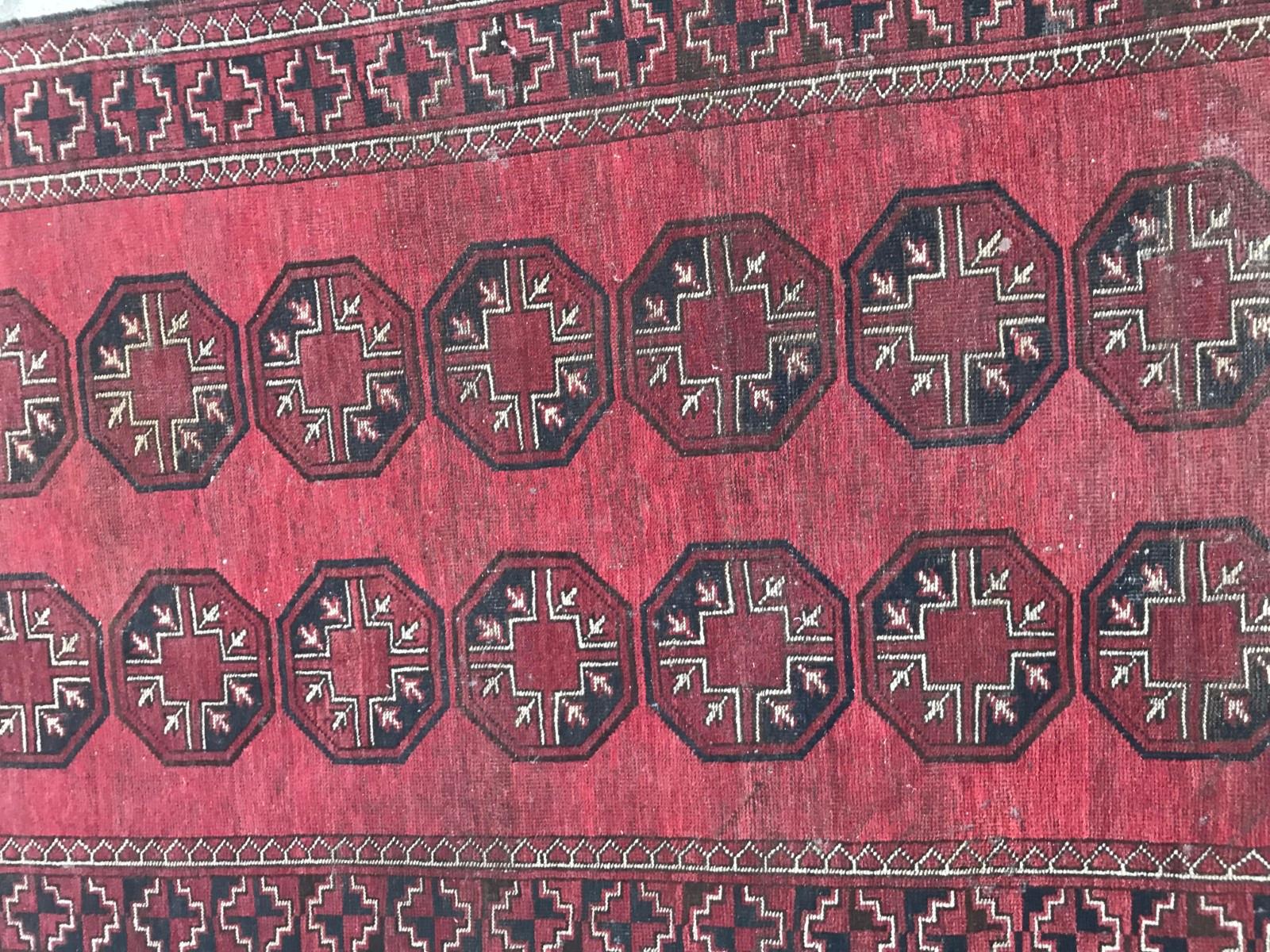 Early 20th century Afghan rug with a Turkmen design and red and black colors, entirely hand knotted with wool velvet on wool foundations.